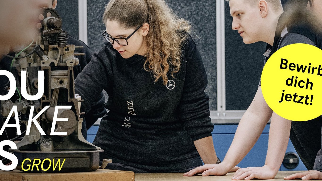 Eine Gruppe von jungen Teammitgliedern analysiert eine mechanische Vorrichtung in einer Werkstatt. Der Slogan 'You make us grow' ist auf der linken Seite zu sehen, begleitet von einem gelben Button mit 'Bewirb dich jetzt!'