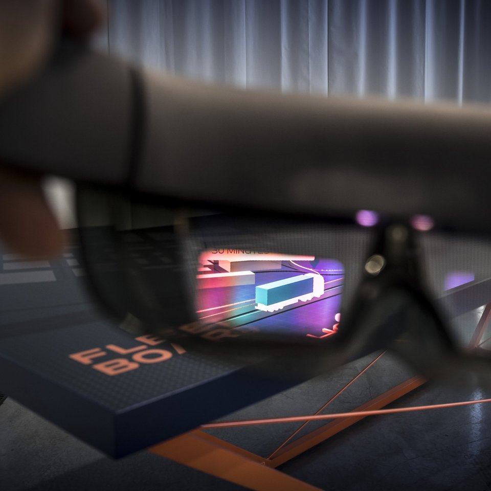 Zukunftsvision Fleetboard HoloDeck: Durch eine HoloLens-Brille entsteht auf einem Tisch eine virtuelle dreidimensionale Landschaft, in der Flottenmanager auf einen Blick Informationen über Fahrer, Lkw und Fracht erhalten.