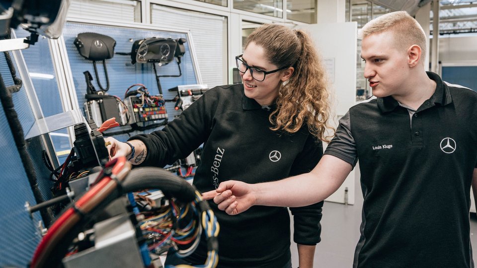 Zwei Mitarbeiter begutachten Fahrzeug-Teile im Werk.