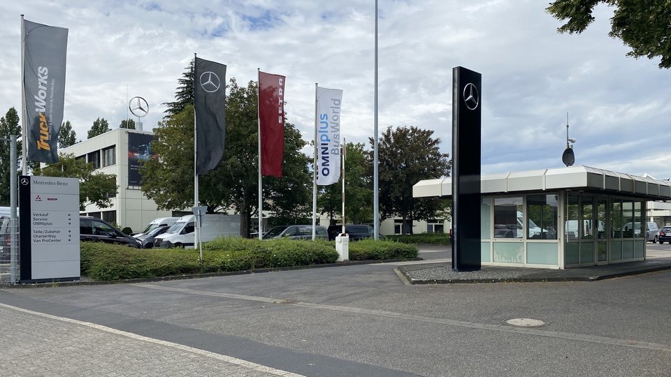 Zufahrt zum Mercedes-Benz Standort Frechen/Köln mit Flaggen von TruckWorks, Omniplus und Setra.