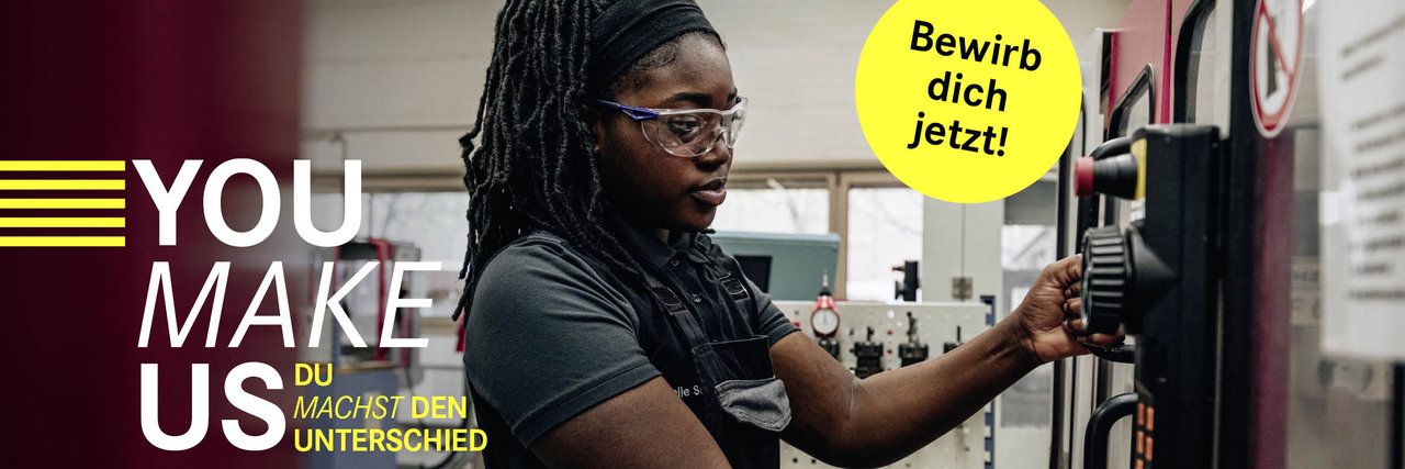 Eine Mitarbeiterin in Arbeitskleidung und mit Schutzbrille bedient konzentriert eine CNC-Maschine in einer Werkshalle, mit dem Slogan „YOU MAKE US – YOU MAKE THE DIFFERENCE“ und einem „Bewirb dich jetzt!“-Button.