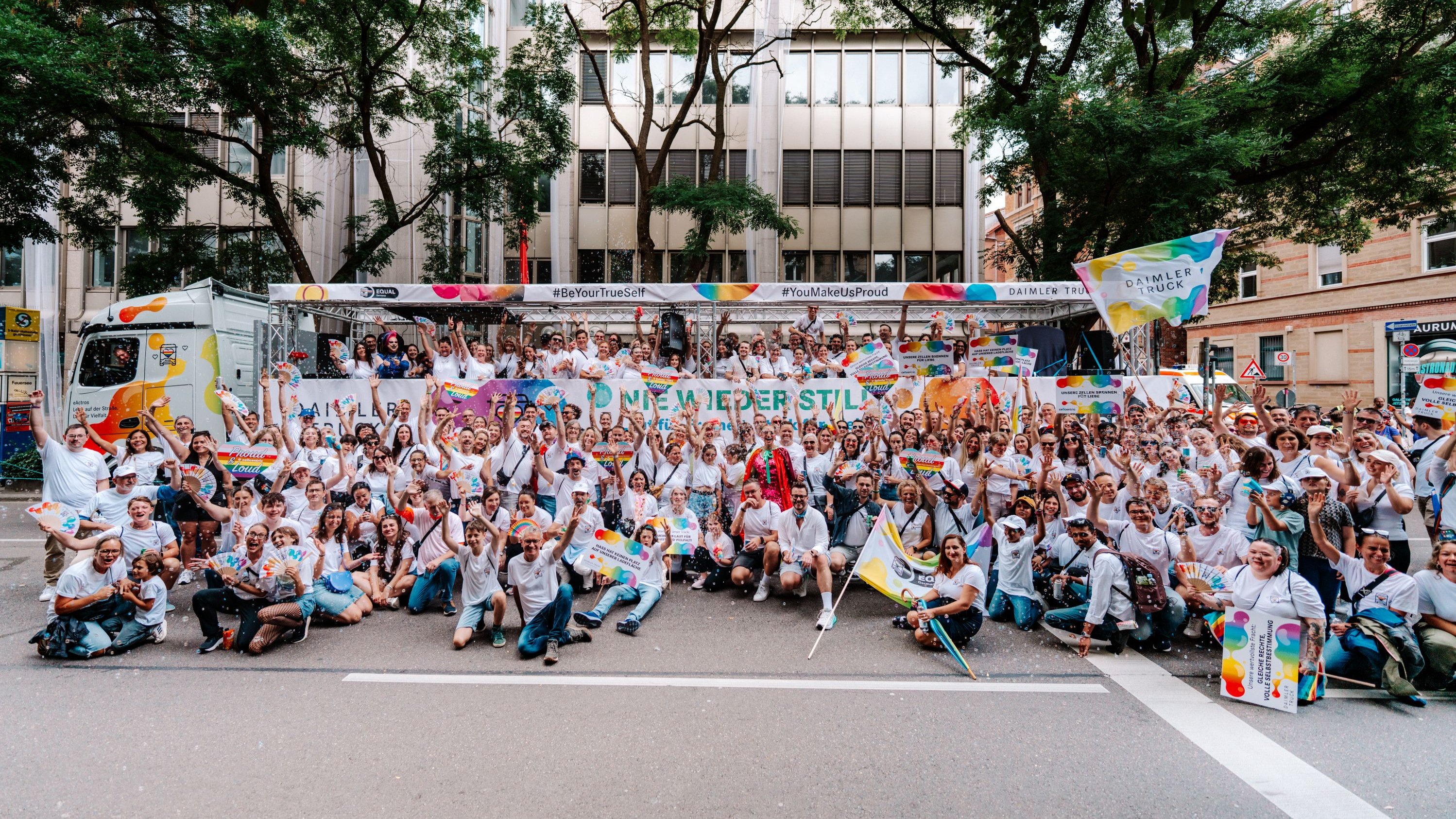 Daimler Truck Mitarbeitende posieren auf einer Pride Veranstaltung vor dem Truck