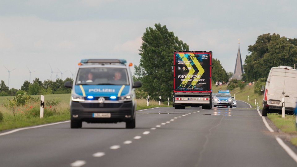Der eActros 600 fährt unter Polizeigeleit rückwärts über öffentliche Straße,