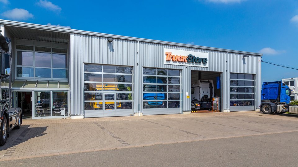 Exterior view of a TruckStore workshop in Erfurt with several parked trucks.