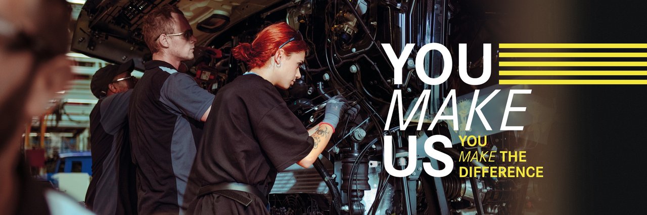 Junge Mitarbeitende montieren Teile an einem Lkw in der Daimler Truck Produktion – Teamarbeit und Einsatz im Ferienjob. Text im Bild: "You make us – You make the difference."