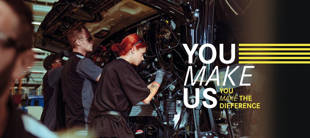 Junge Mitarbeitende montieren Teile an einem Lkw in der Daimler Truck Produktion – Teamarbeit und Einsatz im Ferienjob. Text im Bild: "You make us – You make the difference."