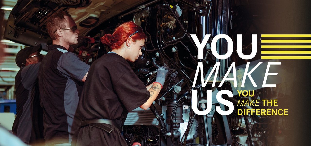 Junge Mitarbeitende montieren Teile an einem Lkw in der Daimler Truck Produktion – Teamarbeit und Einsatz im Ferienjob. Text im Bild: "You make us – You make the difference."