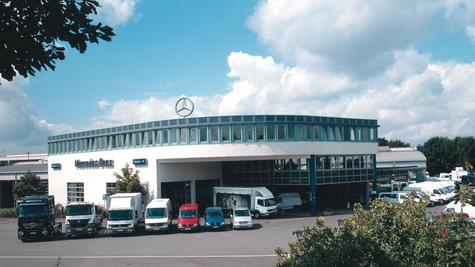 Mercedes-Benz Nutzfahrzeugzentrum am Sunderweg in Dortmund mit einer modernen Glasfassade und mehreren geparkten Transportern und LKW.