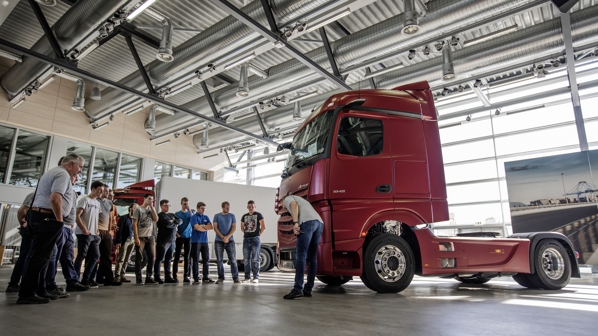 Frisch von der IAA: Die BKF-Auszubildenden erfahren beim TruckTraining etwas über Innovationen in Effizienz, Sicherheit und Assistenzsysteme, Konnektivität und automatisiertes Fahren. Hier wird der Neue Actros erklärt, der als erster Serien-Lkw mit MirrorCam statt Außenspiegeln ausgestattet ist. BEST-BKF – Gewinnertag im Mercedes-Benz Lkw-Werk Wörth: Die junge Trucker-Generation übernimmt das Steuerrad