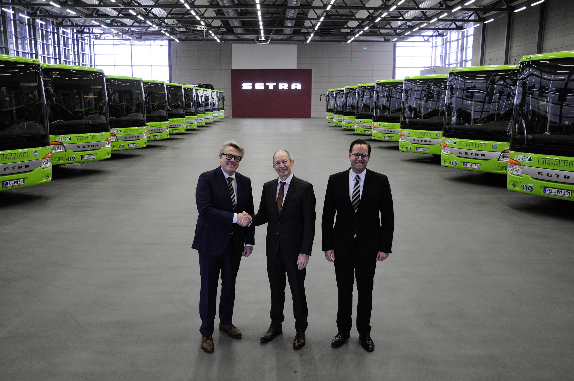 Nach dem Gewinn mehrerer Linienstrecken im mittelhessischen Landkreis Limburg-Weilburg setzt die Medenbach Traffic GmbH auf 20 neue Setra Low Entry Busse. Die Fahrzeuge des Typs S 415 LE business und S 418 LE business werden auf insgesamt acht Linien des Rhein-Main-Verkehrsverbunds (RMV) eingesetzt. Geschäftsführer Peter Medenbach (links) übernahm die Niederflurbusse gemeinsam mit seinem Schwiegersohn Timo Medenbach von Axel Stokinger, Geschäftsleiter der Vertriebsorganisation Deutschland Daimler Buses (Mitte) in Neu-Ulm. Die Euro VI-Fahrzeuge der Setra MultiClass sind mit Böden in eleganter Holzoptik, Sondernutzungsflächen für Kinderwagen, Rollstühle und Fahrräder sowie Anzeigensystemen mit Echtzeitinformationen für die Fahrgäste ausgestattet. Grüne Setra Flotte für Mittelhessen