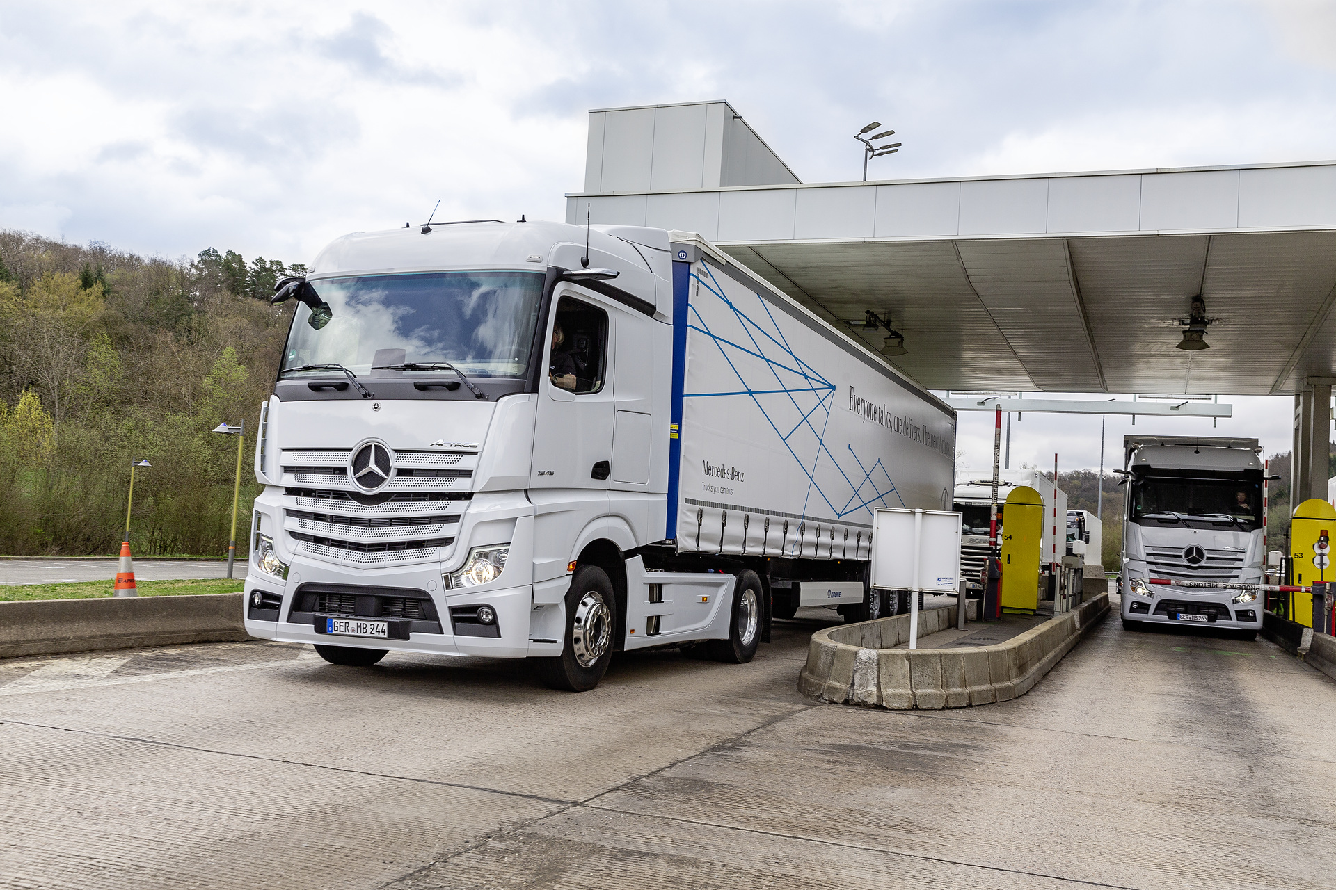 Im Vordergrund: Mercedes-Benz Actros 1846 LS 4x2, Exterieur, arktik-weiß, OM 470 Euro VI mit 335 kW (455 PS), 10,7 L Hubraum, 12-Gang Mercedes PowerShift 3, Active Brake Assist 5, Abstandshalte-Assistent, Verkehrszeichen-Assistent und Abbiege-Assistent, Spurhalte-Assistent, Stabilitätsregel-Assistent, Aufmerksamkeits-Assistent, Active Drive Assist, MirrorCam, Predictive Powertrain Control, L-Fahrerhaus StreamSpace Mercedes-Benz Actros mit Active Brake Assist 5 und Abbiege-Assistent, Active Drive Assist, MirrorCam