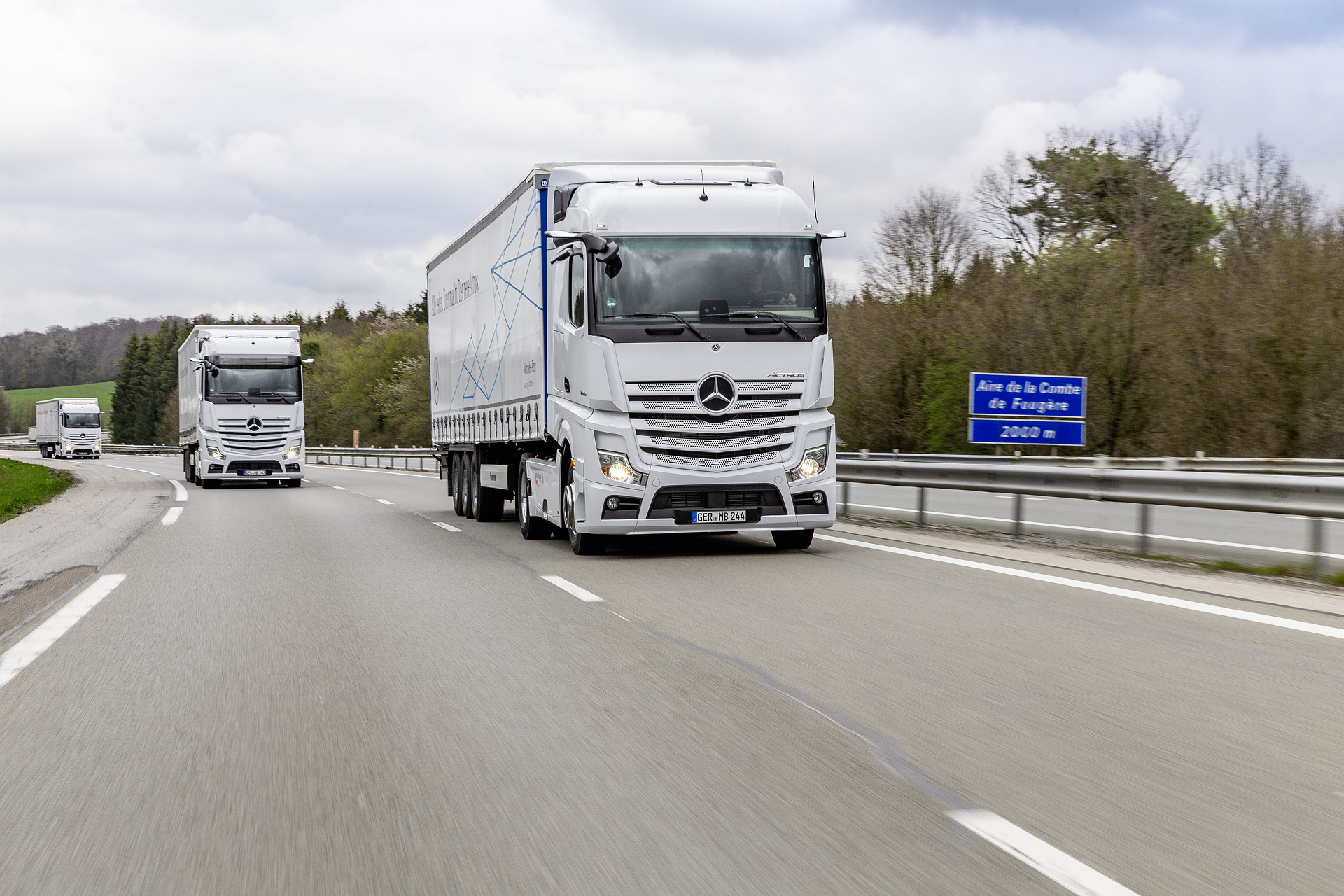 Im Vordergrund: Mercedes-Benz Actros 1846 LS 4x2, Exterieur, arktik-weiß, OM 470 Euro VI mit 335 kW (455 PS), 10,7 L Hubraum, 12-Gang Mercedes PowerShift 3, Active Brake Assist 5, Abstandshalte-Assistent, Verkehrszeichen-Assistent und Abbiege-Assistent, Spurhalte-Assistent, Stabilitätsregel-Assistent, Aufmerksamkeits-Assistent, Active Drive Assist, MirrorCam, Predictive Powertrain Control, L-Fahrerhaus StreamSpace Mercedes-Benz Actros mit Active Brake Assist 5 und Abbiege-Assistent, Active Drive Assist, MirrorCam