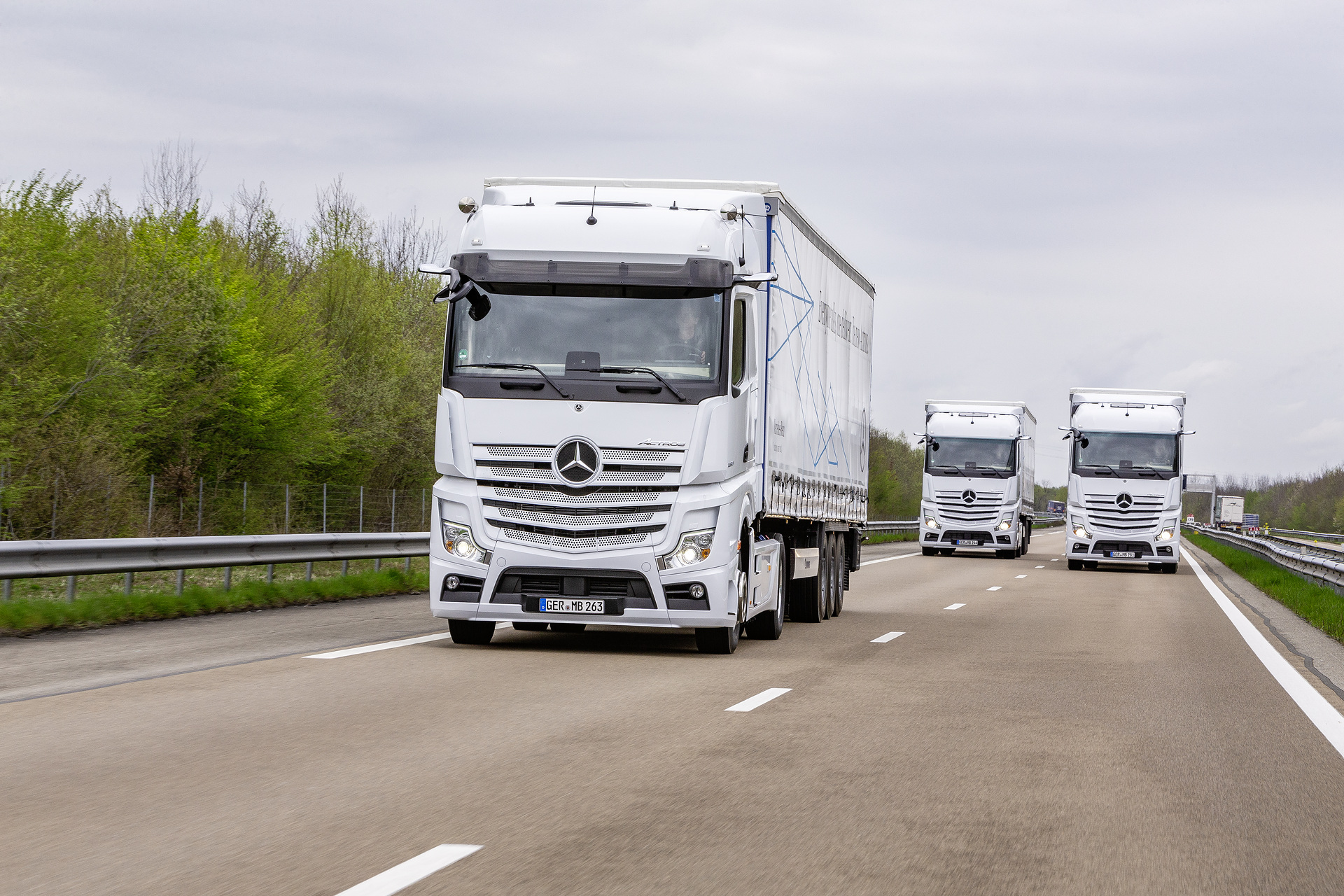 Im Vordergrund: Mercedes-Benz Actros 1853 LS 4x2, Exterieur, arktik-weiß, OM 471 Euro VI mit 390 kW (530 PS), 12,8 L Hubraum, 12-Gang Mercedes PowerShift 3, Active Brake Assist 5, Abstandshalte-Assistent, Verkehrszeichen-Assistent und Abbiege-Assistent, Spurhalte-Assistent, Stabilitätsregel-Assistent, Aufmerksamkeits-Assistent, Active Drive Assist, MirrorCam, Predictive Powertrain Control, BiXenon-Scheinwerfer, L-Fahrerhaus BigSpace Mercedes-Benz Actros mit Active Brake Assist 5 und Abbiege-Assistent, Active Drive Assist, MirrorCam