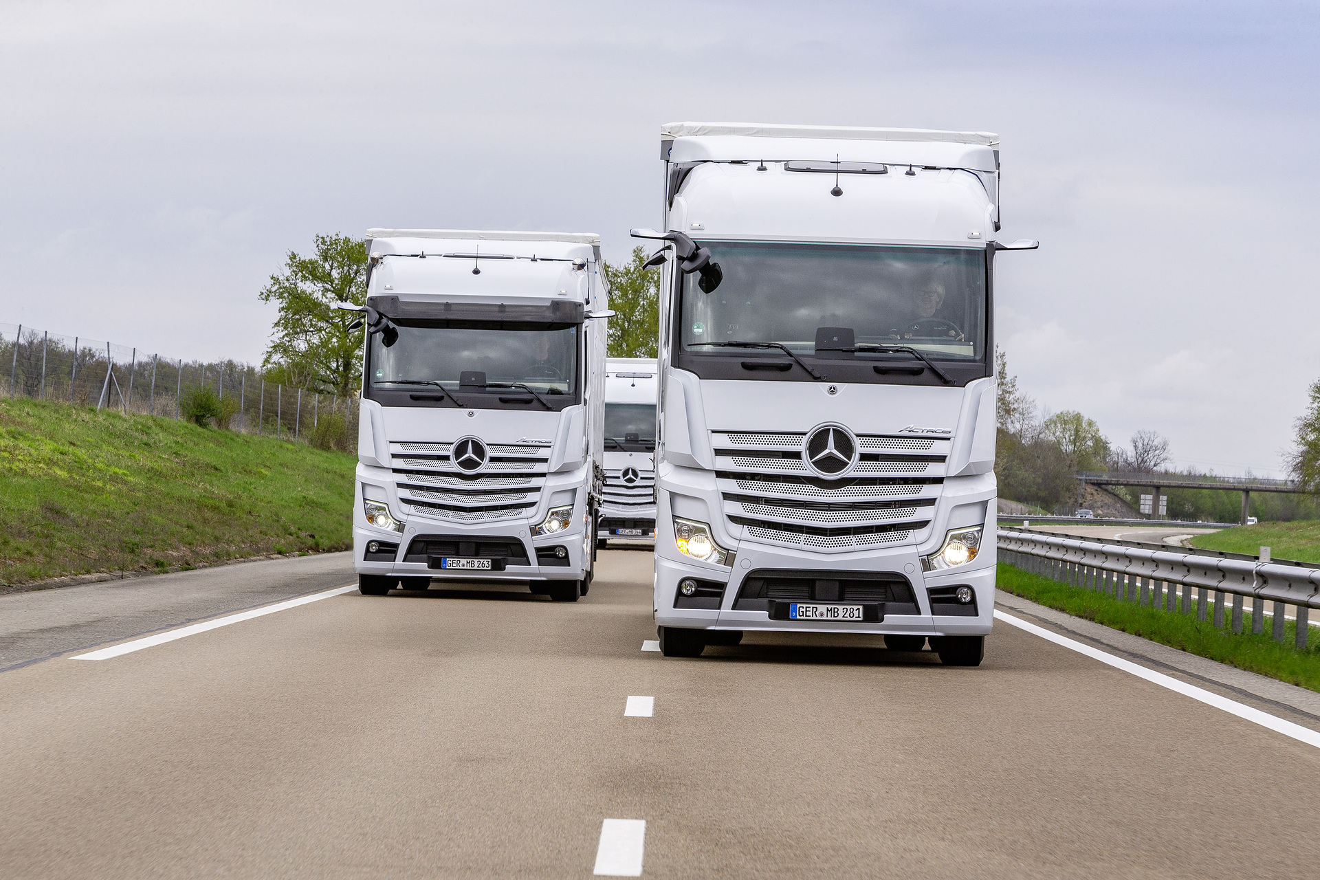 Im Vordergrund: Mercedes-Benz Actros 1845 LS 4x2, Exterieur, arktik-weiß, OM 471 Euro VI mit 330 kW (449 PS), 12,8 L Hubraum, 12-Gang Mercedes PowerShift 3, Active Brake Assist 5, Abstandshalte-Assistent, Verkehrszeichen-Assistent und Abbiege-Assistent, Spurhalte-Assistent, Stabilitätsregel-Assistent, Aufmerksamkeits-Assistent, Active Drive Assist, MirrorCam, Predictive Powertrain Control, L-Fahrerhaus StreamSpace Mercedes-Benz Actros mit Active Brake Assist 5 und Abbiege-Assistent, Active Drive Assist, MirrorCam
