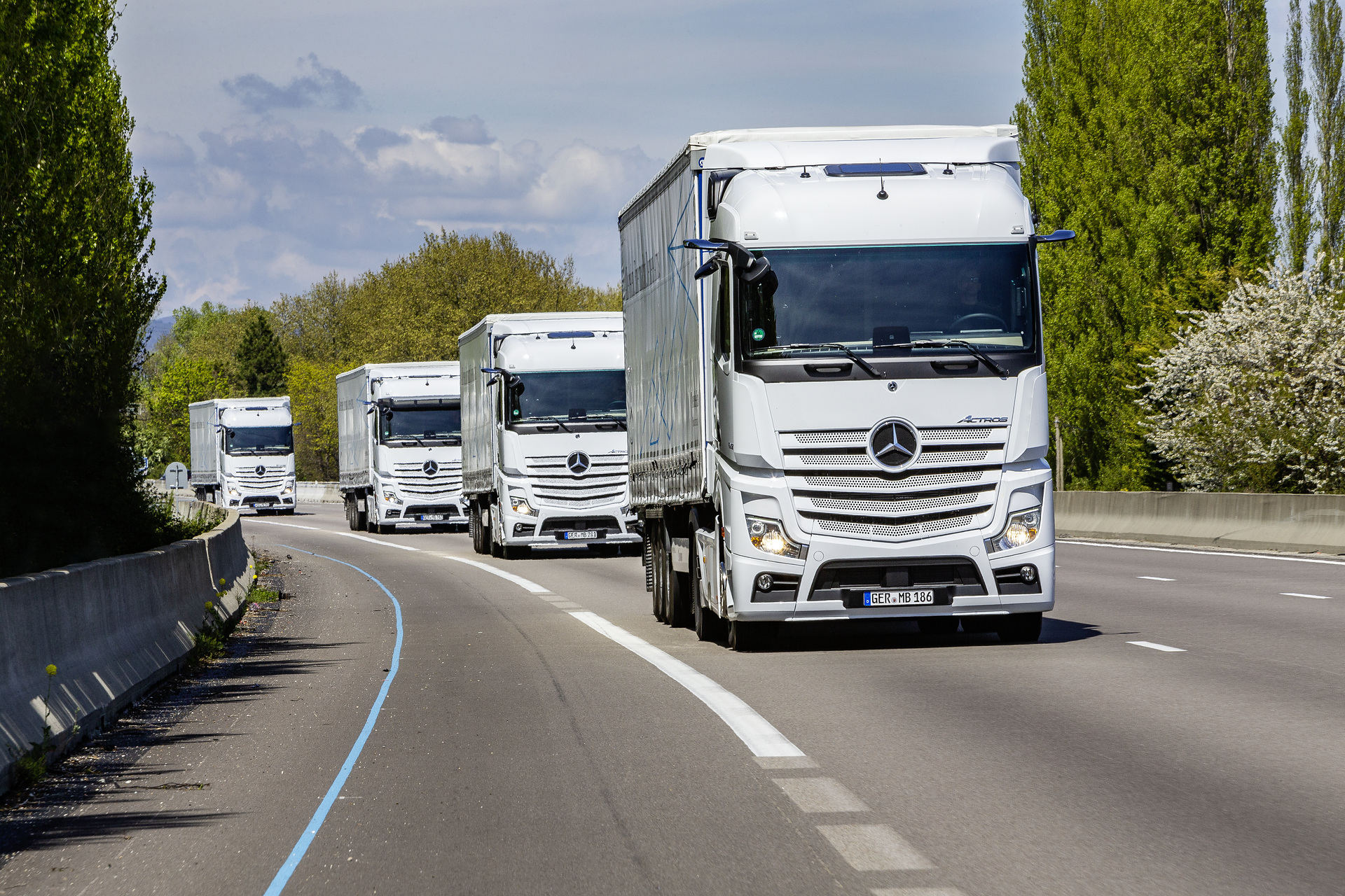 Im Vordergrund: Mercedes-Benz Actros 1845 LS 4x2, Exterieur, arktik-weiß, OM 471 Euro VI mit 330 kW (449 PS), 12,8 L Hubraum, 12-Gang Mercedes PowerShift 3, Active Brake Assist 5, Abstandshalte-Assistent, Verkehrszeichen-Assistent und Abbiege-Assistent, Spurhalte-Assistent, Stabilitätsregel-Assistent, Aufmerksamkeits-Assistent, Active Drive Assist, MirrorCam, Predictive Powertrain Control, L-Fahrerhaus StreamSpace Mercedes-Benz Actros mit Active Brake Assist 5 und Abbiege-Assistent, Active Drive Assist, MirrorCam