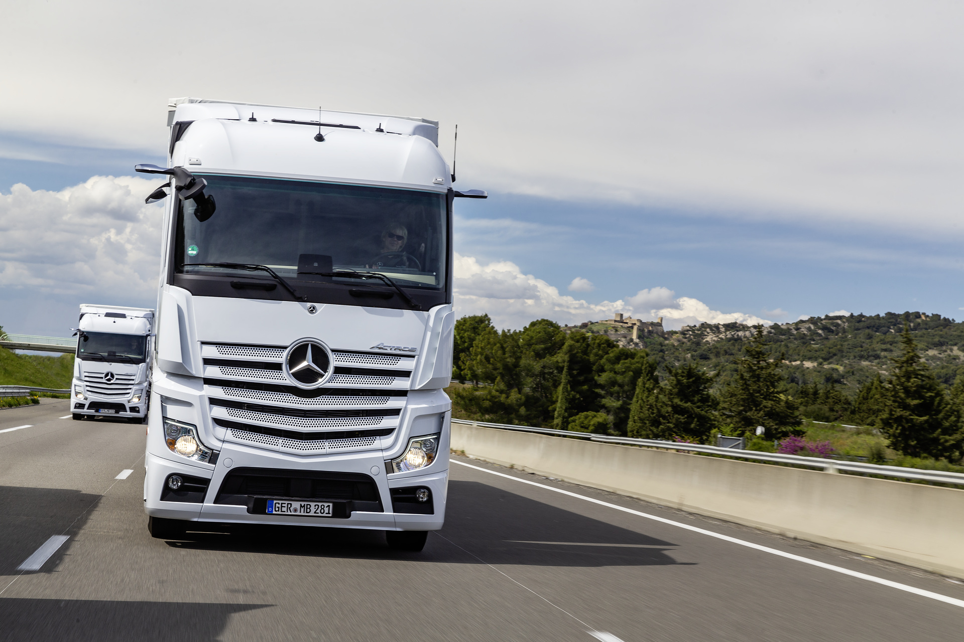 Im Vordergrund: Mercedes-Benz Actros 1845 LS 4x2, Exterieur, arktik-weiß, OM 471 Euro VI mit 330 kW (449 PS), 12,8 L Hubraum, 12-Gang Mercedes PowerShift 3, Active Brake Assist 5, Abstandshalte-Assistent, Verkehrszeichen-Assistent und Abbiege-Assistent, Spurhalte-Assistent, Stabilitätsregel-Assistent, Aufmerksamkeits-Assistent, Active Drive Assist, MirrorCam, Predictive Powertrain Control, L-Fahrerhaus StreamSpace Mercedes-Benz Actros mit Active Brake Assist 5 und Abbiege-Assistent, Active Drive Assist, MirrorCam