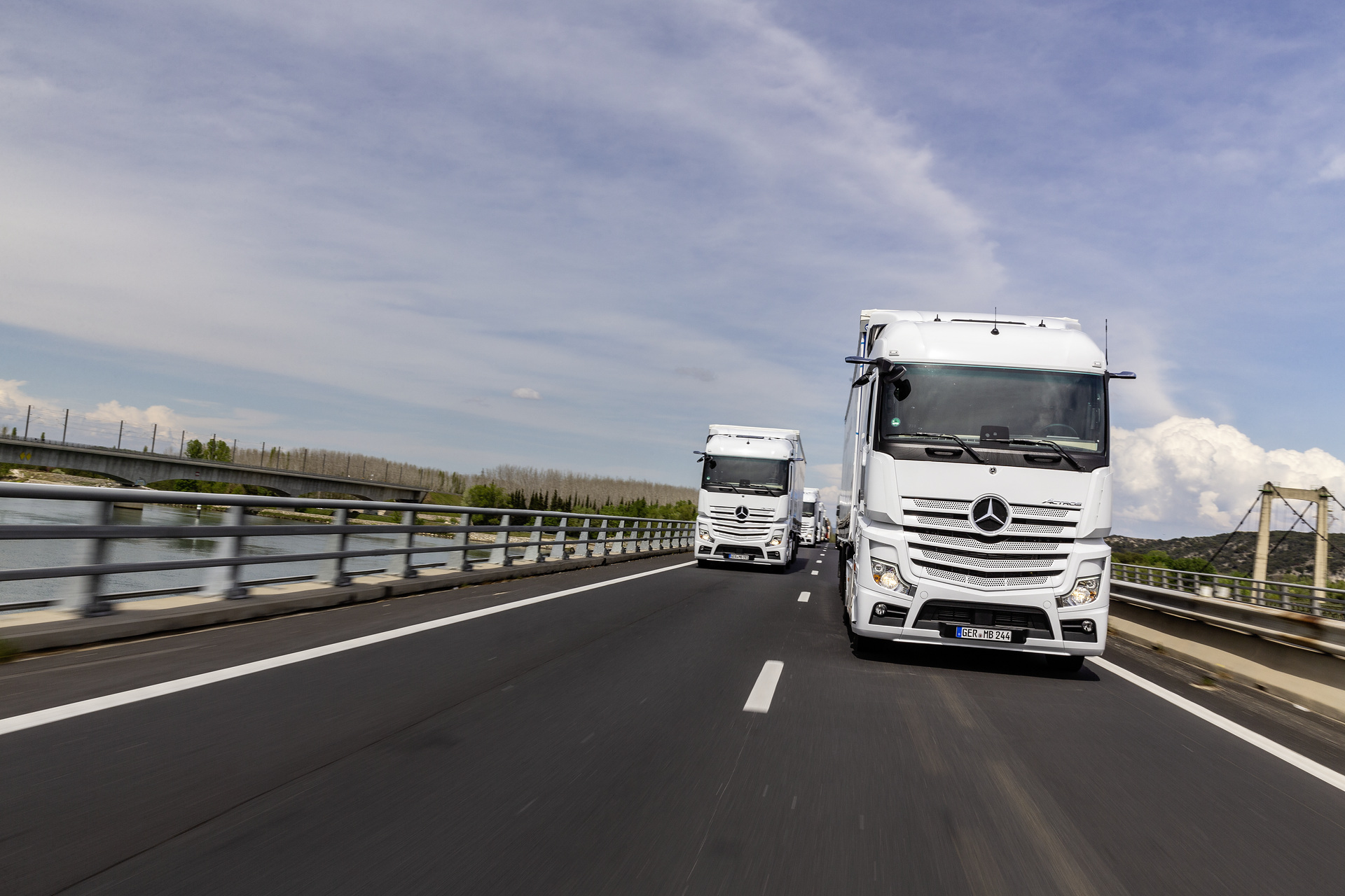 Im Vordergrund: Mercedes-Benz Actros 1846 LS 4x2, Exterieur, arktik-weiß, OM 470 Euro VI mit 335 kW (455 PS), 10,7 L Hubraum, 12-Gang Mercedes PowerShift 3, Active Brake Assist 5, Abstandshalte-Assistent, Verkehrszeichen-Assistent und Abbiege-Assistent, Spurhalte-Assistent, Stabilitätsregel-Assistent, Aufmerksamkeits-Assistent, Active Drive Assist, MirrorCam, Predictive Powertrain Control, L-Fahrerhaus StreamSpace Mercedes-Benz Actros mit Active Brake Assist 5 und Abbiege-Assistent, Active Drive Assist, MirrorCam
