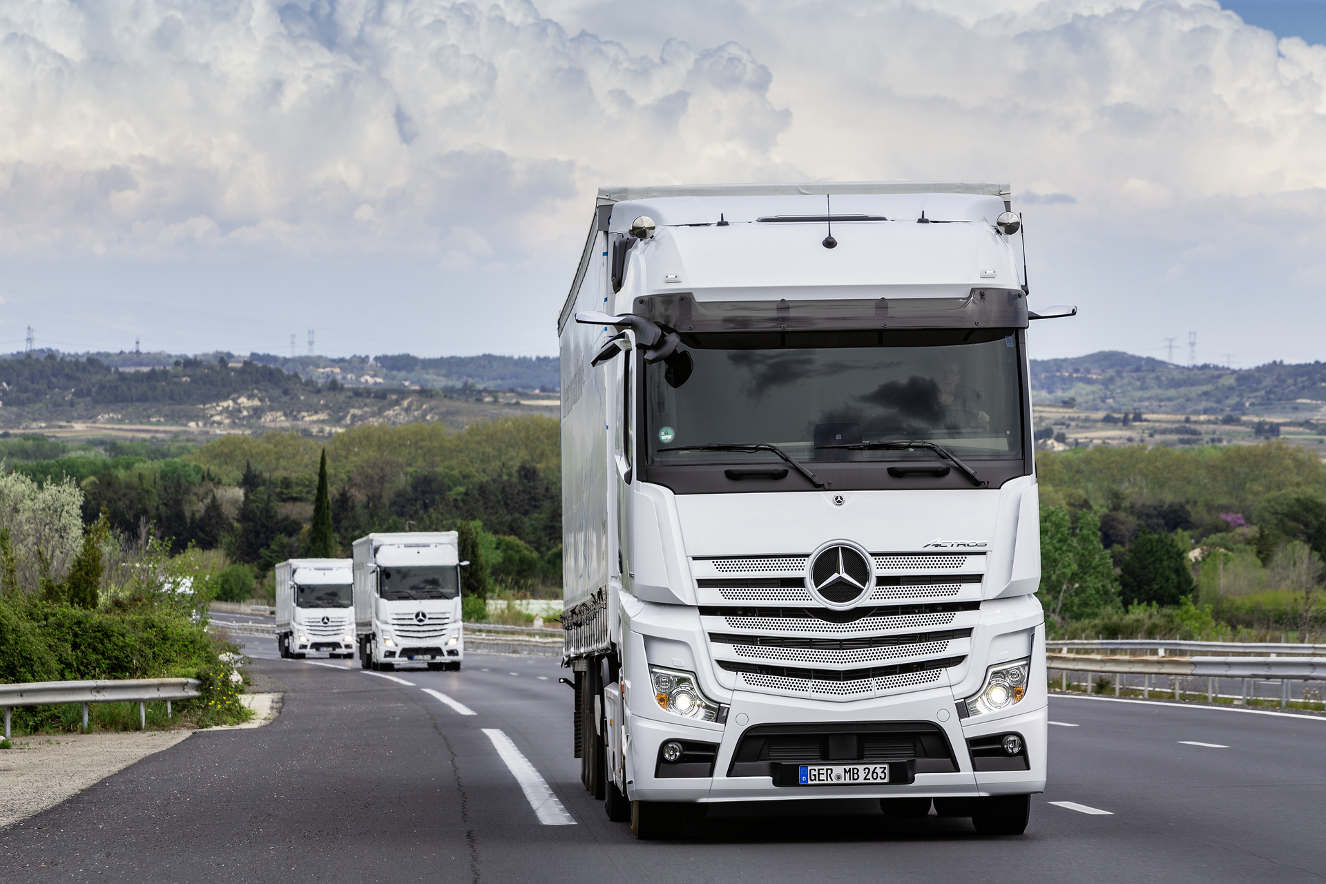Im Vordergrund: Mercedes-Benz Actros 1853 LS 4x2, Exterieur, arktik-weiß, OM 471 Euro VI mit 390 kW (530 PS), 12,8 L Hubraum, 12-Gang Mercedes PowerShift 3, Active Brake Assist 5, Abstandshalte-Assistent, Verkehrszeichen-Assistent und Abbiege-Assistent, Spurhalte-Assistent, Stabilitätsregel-Assistent, Aufmerksamkeits-Assistent, Active Drive Assist, MirrorCam, Predictive Powertrain Control, BiXenon-Scheinwerfer, L-Fahrerhaus BigSpace Mercedes-Benz Actros mit Active Brake Assist 5 und Abbiege-Assistent, Active Drive Assist, MirrorCam