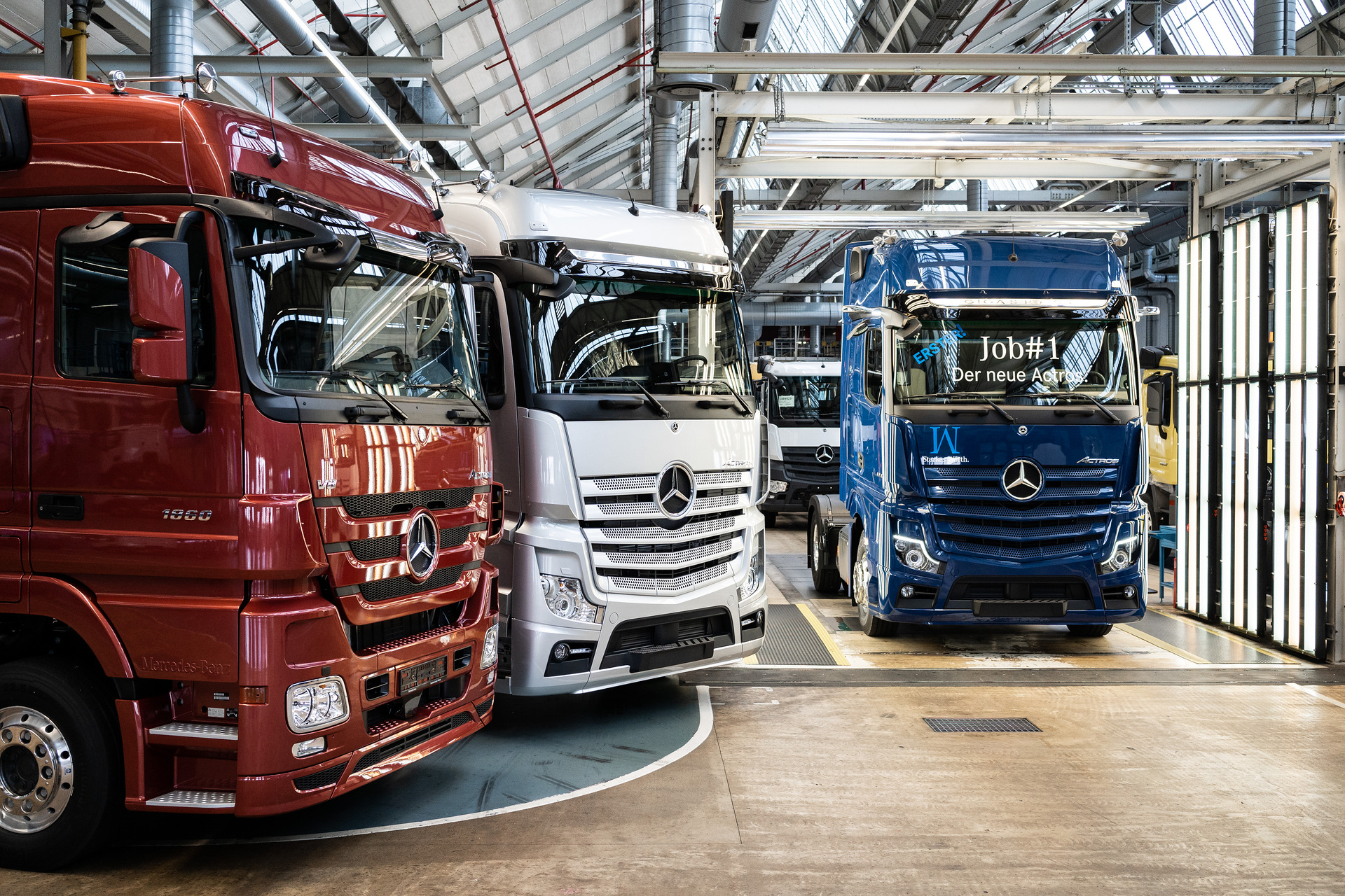 A milestone at the Mercedes-Benz plant in Wörth: The first new Mercedes-Benz Actros in sapphire-blue next to its predecessor (in silver) and its predecessor before (in red) is ready for its customer. Mercedes-Benz Actros