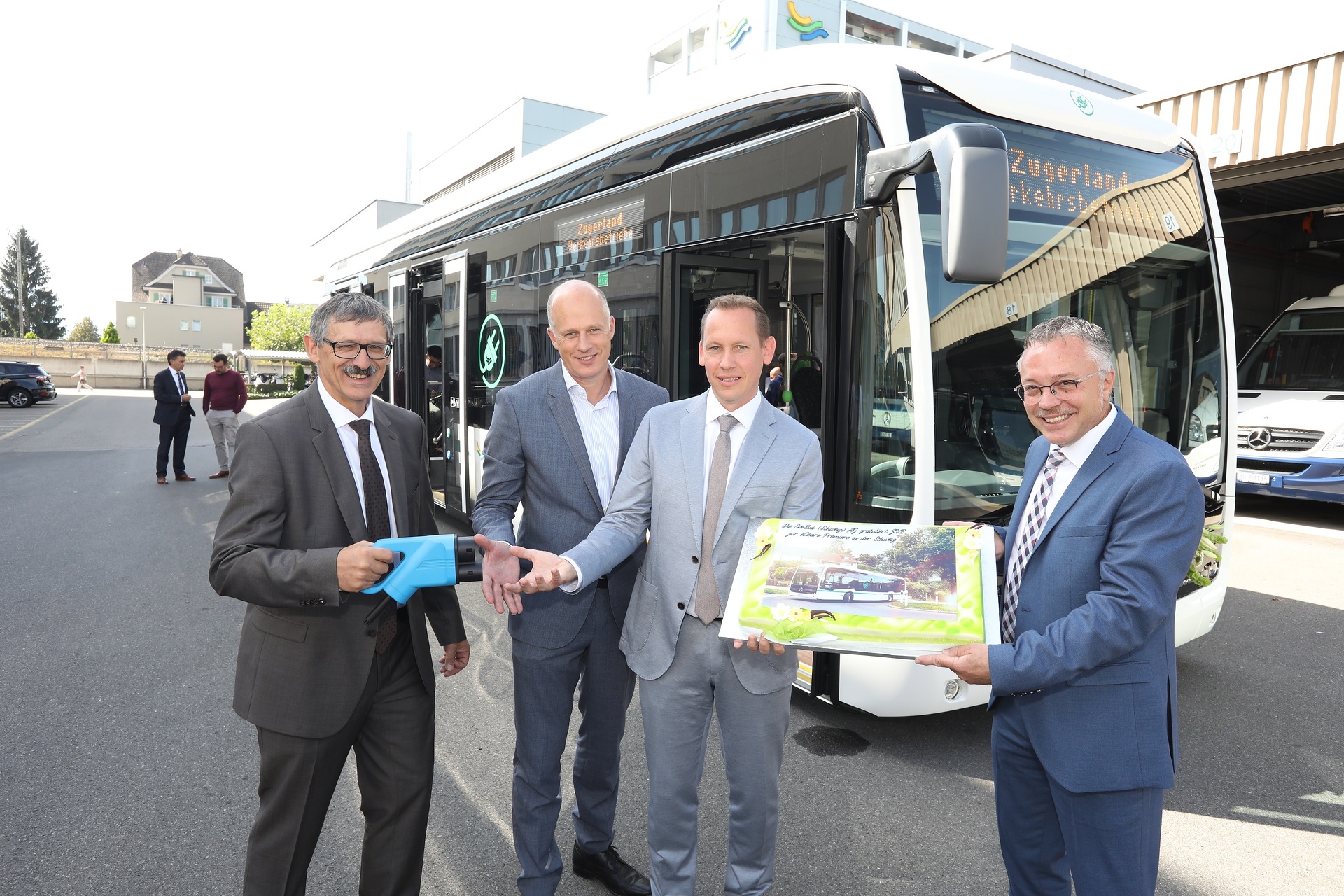 Frank Scherhag, CEO EvoBus (Schweiz) AG (rechts), und Armin Krieg, EvoBus (Schweiz) AG (links), überreichten die Foto-Torte der ersten eCitaro an Peter Letter, Verwaltungsratspräsident ZVB (2. von links), und Cyrill Weber, CEO ZVB (2. von rechts).