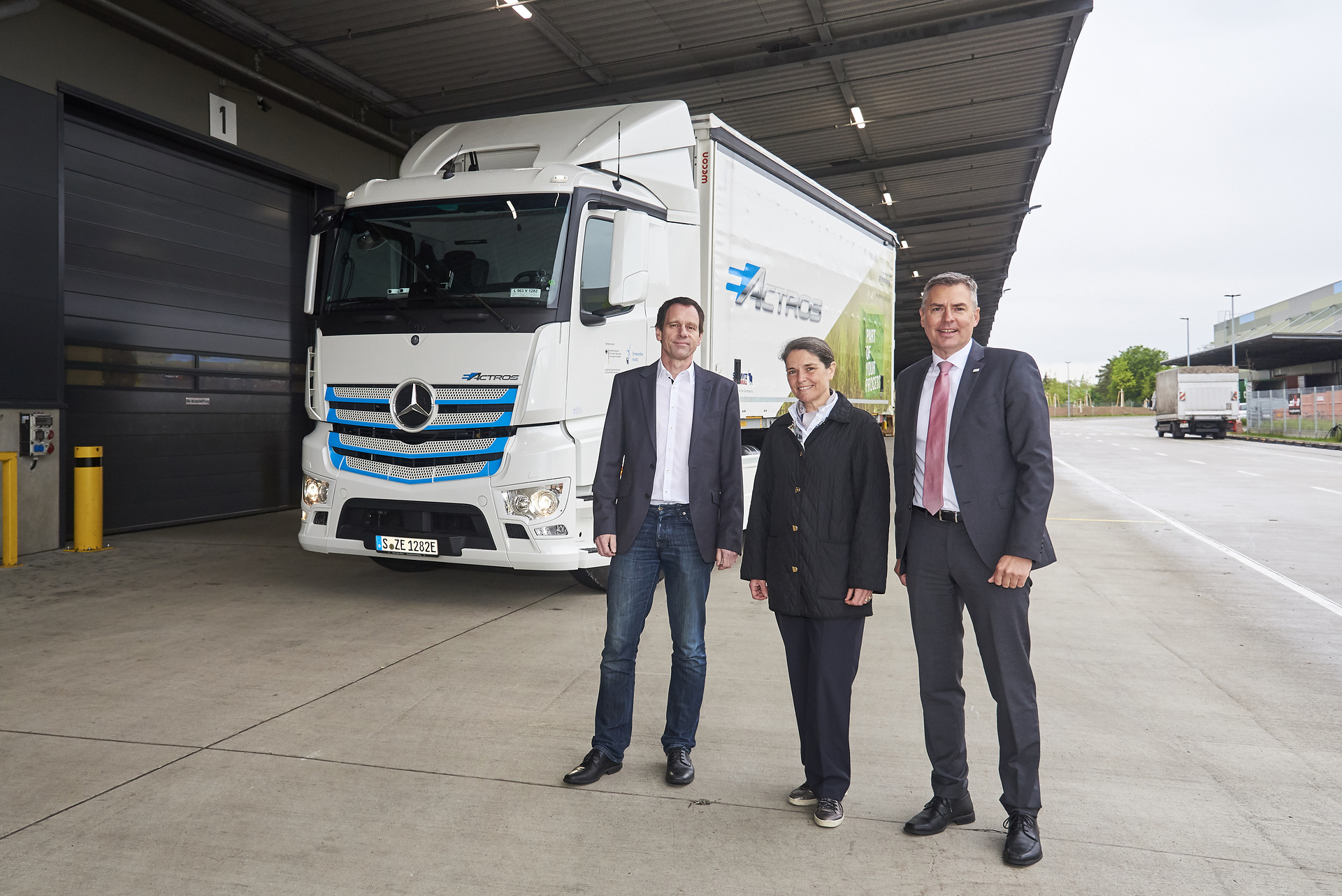 Dr. Thomas Grobel, Leiter der Logistikplanung im Mercedes-Benz Werk Mannheim (links), übergibt den vollelektrischen eActros an Marie-Elizabeth Benois, Gesellschafterin der Pfenning-Gruppe, und Matthias Schadler, Geschäftsführer von Pfenning Logistics. Mercedes-Benz Trucks zieht Zwischenbilanz: Elektro-Lkw eActros seit über einem Jahr erfolgreich im Kundeneinsatz