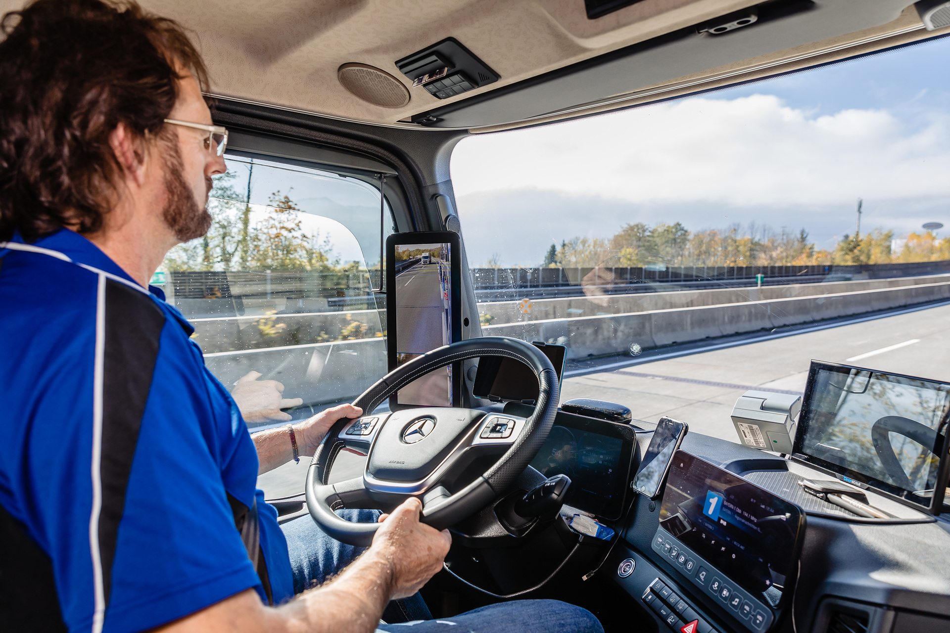Die Fahrer bei Lagermax schätzen am neuen Actros besonders das Multimedia-Cockpit und die MirrorCam. Im Bild: Fahrer Christian Lippeck. Effizient unterwegs, flexibel im Aufbau: neuer Actros erstmals als offener Autotransporter