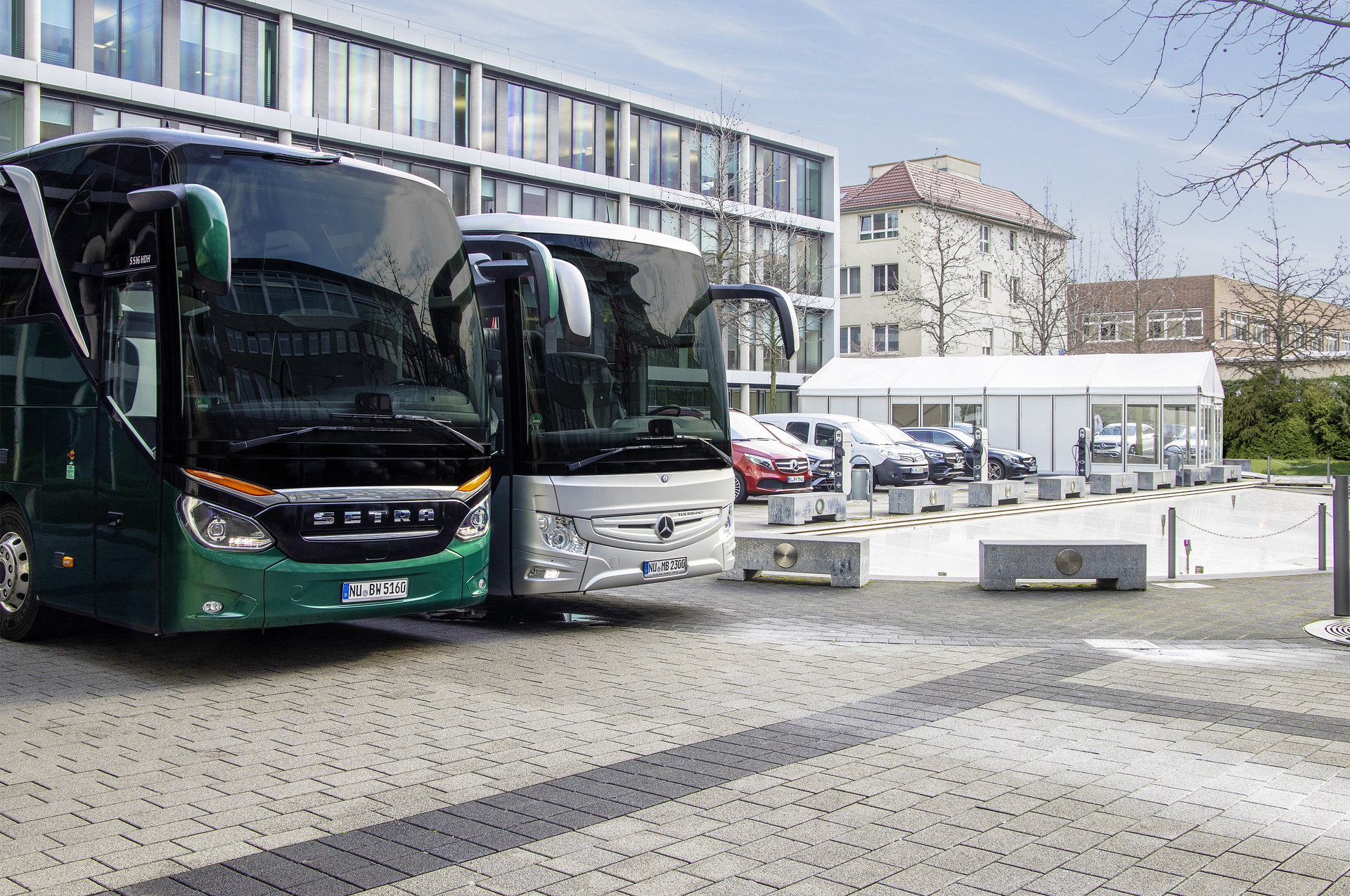 25 Jahre nach der Gründung der EvoBus GmbH wurde das Bild, das anlässlich der Unterzeichnung des notariellen Kaufvertrags zur Übernahme des Busherstellers Kässbohrer durch die Mercedes-Benz AG entstand, nachgestellt. Rechts ein Mercedes-Benz Tourismo, links eine Setra TopClass S 516 HDH. Omnibusse von Mercedes-Benz und Setra – seit 25 Jahren erfolgreich im Omnibusbau