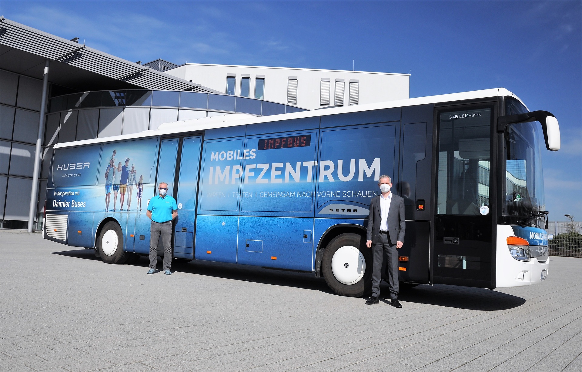 Dr. Jens Heinemann, Leiter Daimler Buses Vertrieb Privatkunden Deutschland, übergibt den neuen Impfbus an Thomas Görtler, Leiter Impfen und Testen bei der Huber Group. Setra Impfbus nimmt Fahrt auf