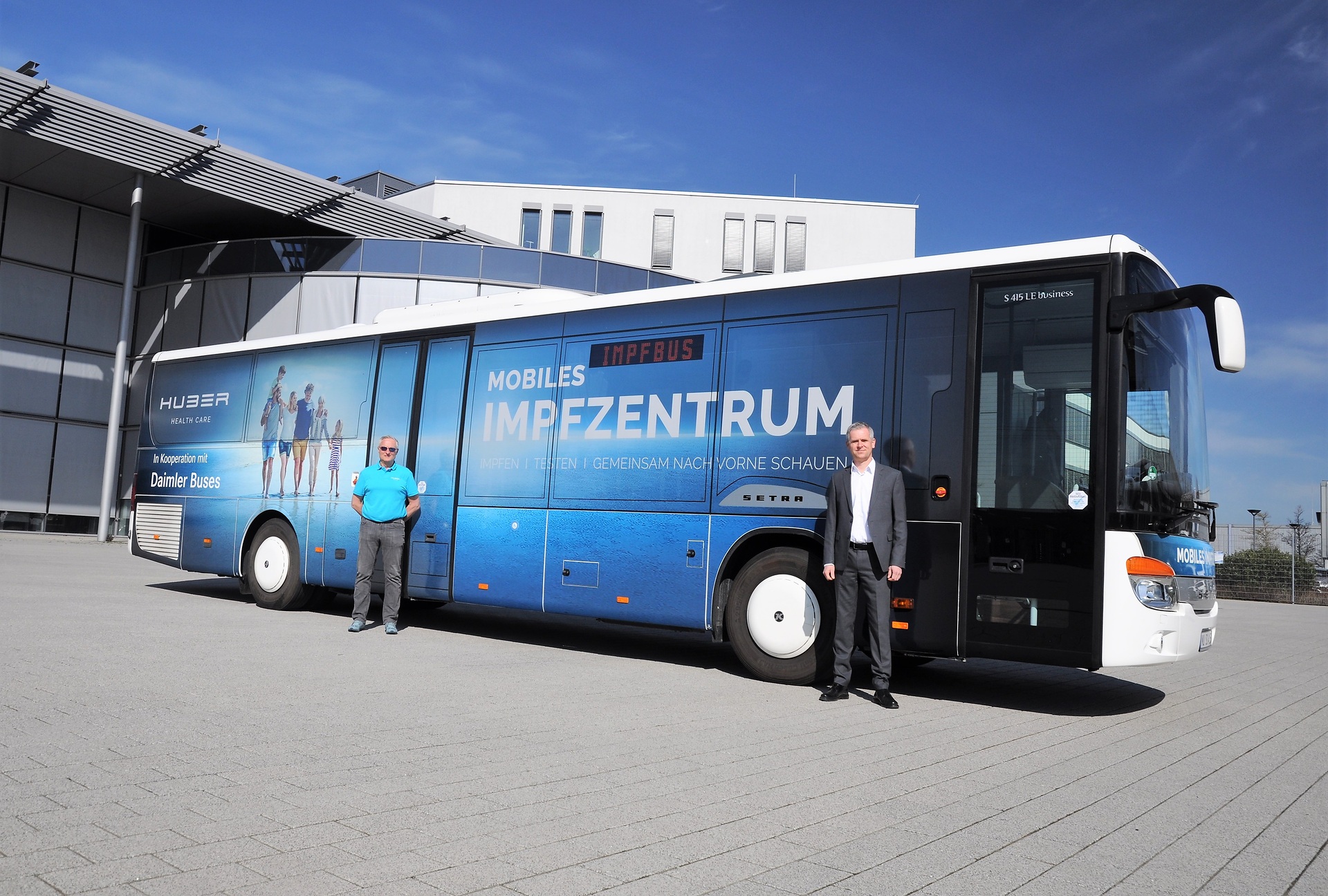 Dr. Jens Heinemann, Leiter Daimler Buses Vertrieb Privatkunden Deutschland, übergibt den neuen Impfbus an Thomas Görtler, Leiter Impfen und Testen bei der Huber Group. Setra Impfbus nimmt Fahrt auf
