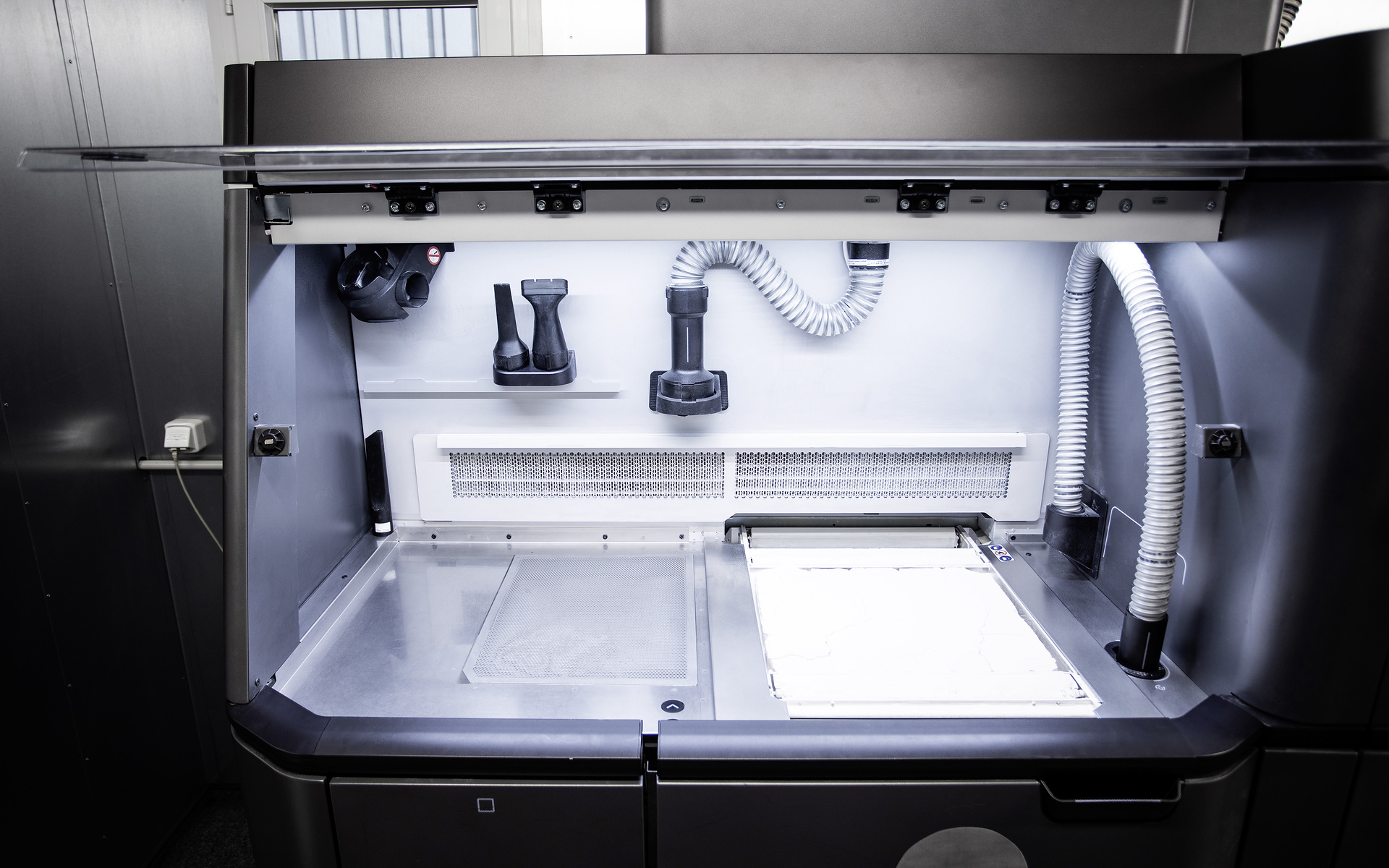 An einer Prozessstation wird das benötigte Pulver vorbereitet und das 3D-gedruckte Ersatzteil im Nachgang vom Restpulver befreit. Mobiles 3D-Druck-Center für noch mehr Kundennähe und schnelle Ersatzteilverfügbarkeit