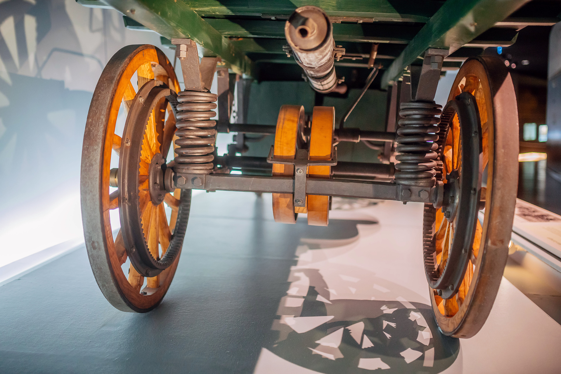 Mercedes-Benz Museum, Raum Mythos 1: Die Erfindung des Automobils. Daimler Motor-Lastwagen aus dem Jahr 1898, der älteste existierende Original-Lkw der Welt. Aufnahme der Fahrzeugunterseite mit schraubengefederter Achse und Riemenscheiben. Daimler Motor-Lastwagen von 1898: 1,25 Tonnen Nutzlast mit nur 4,1 kW (5,6 PS)