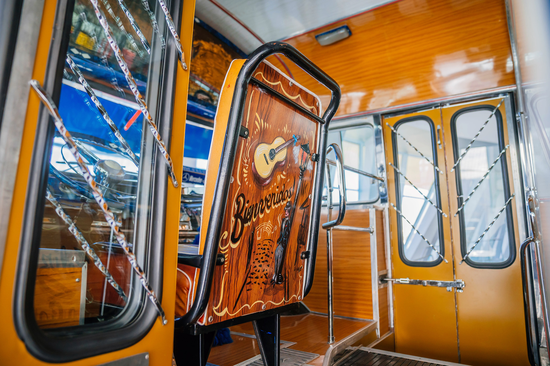 Mercedes-Benz Museum, Collection Room 1: Gallery of Voyagers. Mercedes-Benz LO 1112 bus from 1969. In Buenos Aires, Argentina, the richly decorated “colectivo” buses were an important part of local public transport for decades. View through the entrance door. What do a Mercedes-Benz bus and tango have in common?