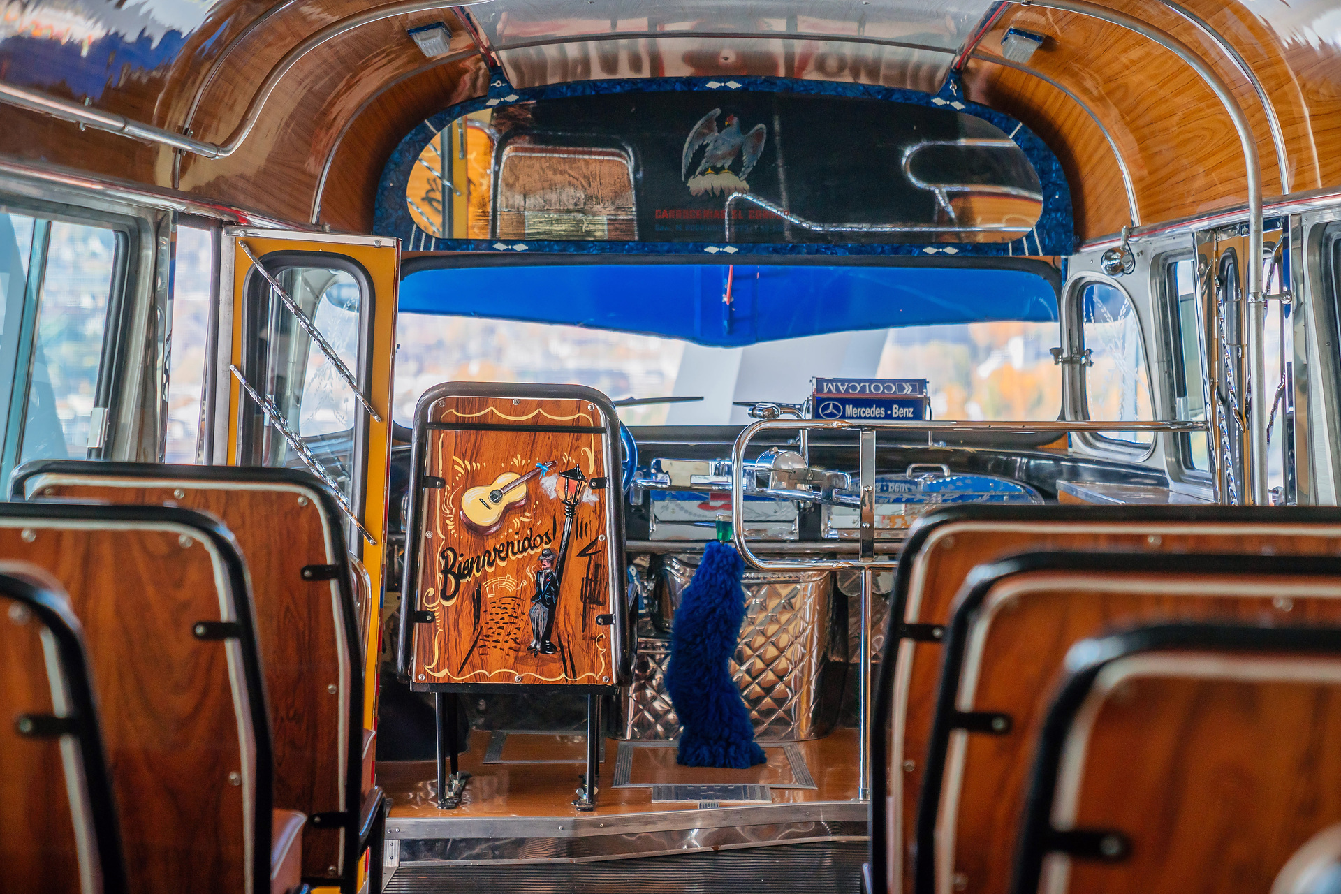 Mercedes-Benz Museum, Collection Room 1: Gallery of Voyagers. Mercedes-Benz LO 1112 bus from 1969. In Buenos Aires, Argentina, the richly decorated “colectivo” buses were an important part of local public transport for decades. View through the centre aisle to the front. What do a Mercedes-Benz bus and tango have in common?