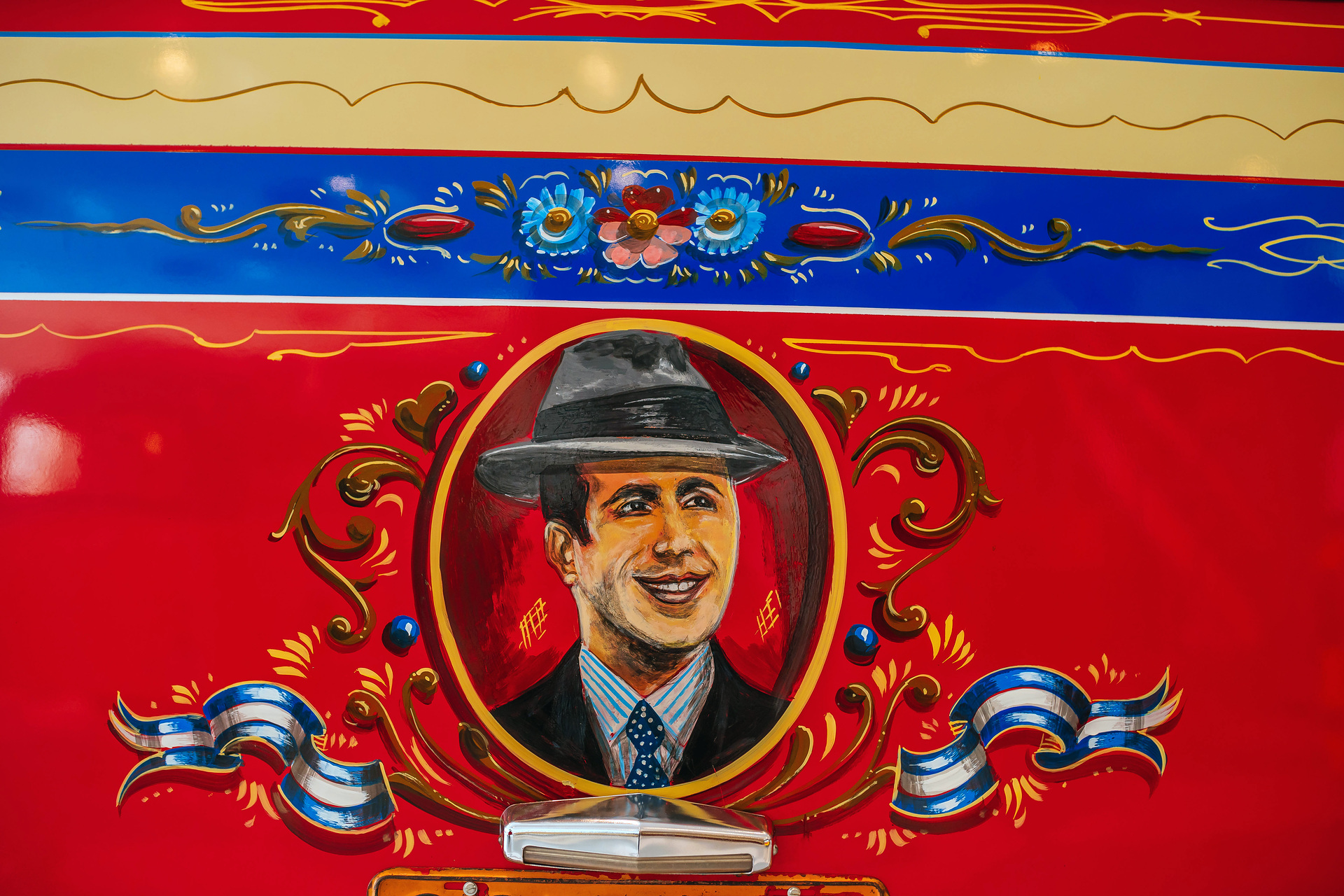 Mercedes-Benz Museum, Collection Room 1: Gallery of Voyagers. Mercedes-Benz LO 1112 bus from 1969. In Buenos Aires, Argentina, the richly decorated “colectivo” buses were an important part of local public transport for decades. Portrait painting of tango singer and composer Carlos Gardel at the rear of the vehicle. What do a Mercedes-Benz bus and tango have in common?