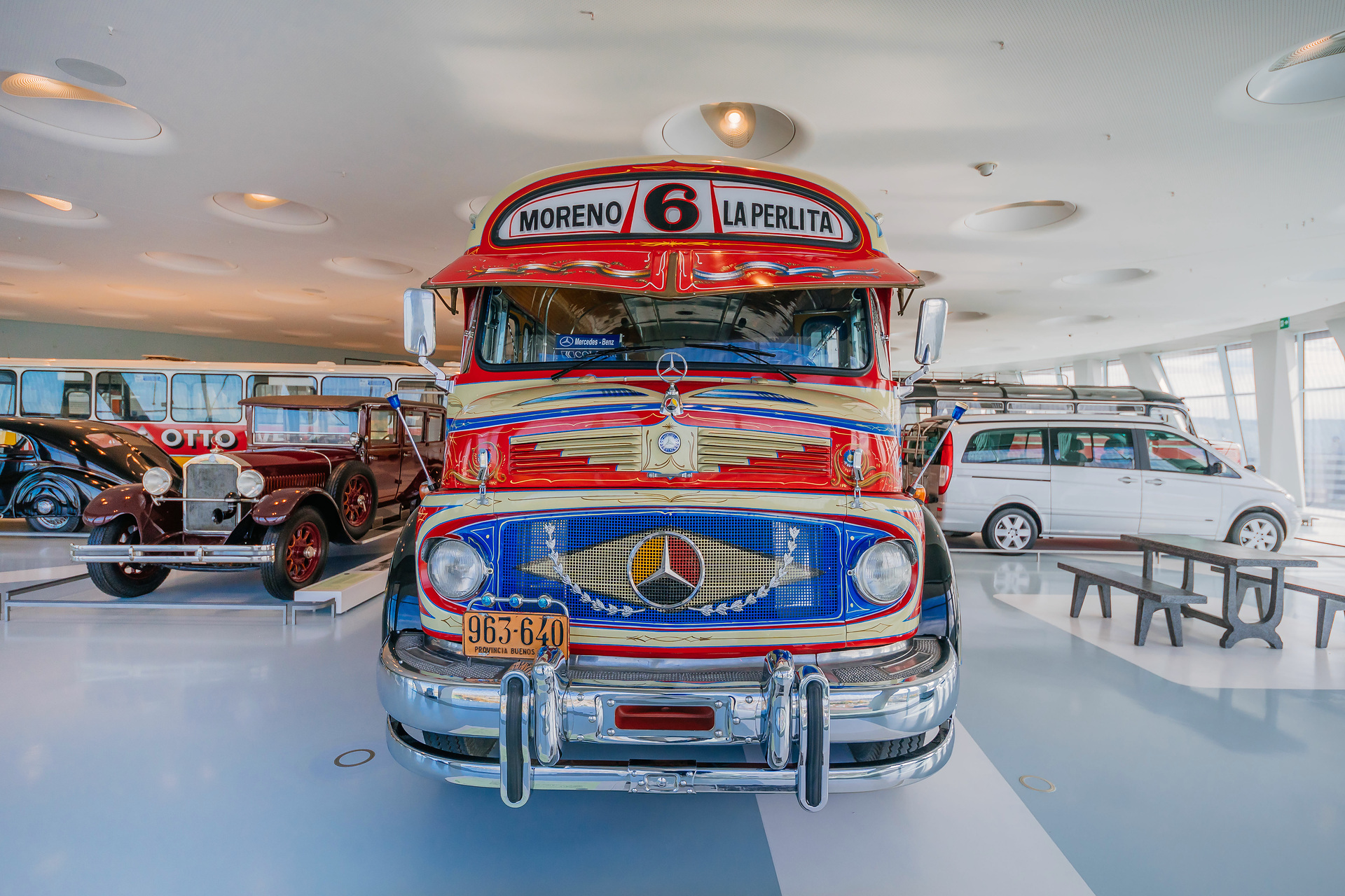 Mercedes-Benz Museum, Collection Room 1: Gallery of Voyagers. Mercedes-Benz LO 1112 bus from 1969. In Buenos Aires, Argentina, the richly decorated “colectivo” buses were an important part of local public transport for decades. Front view. What do a Mercedes-Benz bus and tango have in common?