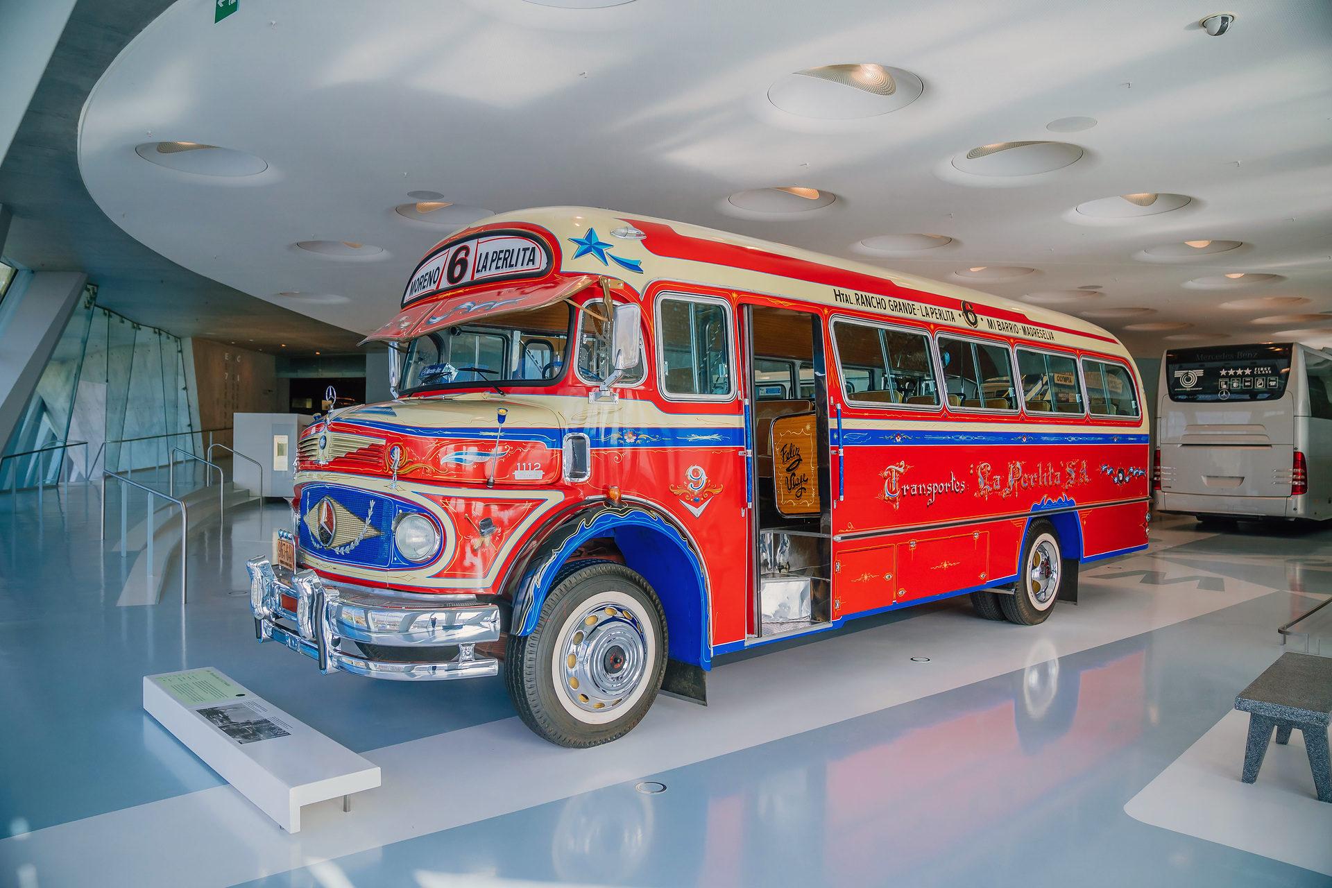 Mercedes-Benz Museum, Collection Room 1: Gallery of Voyagers. Mercedes-Benz LO 1112 bus from 1969. In Buenos Aires, Argentina, the richly decorated “colectivo” buses were an important part of local public transport for decades. Front left view. What do a Mercedes-Benz bus and tango have in common?