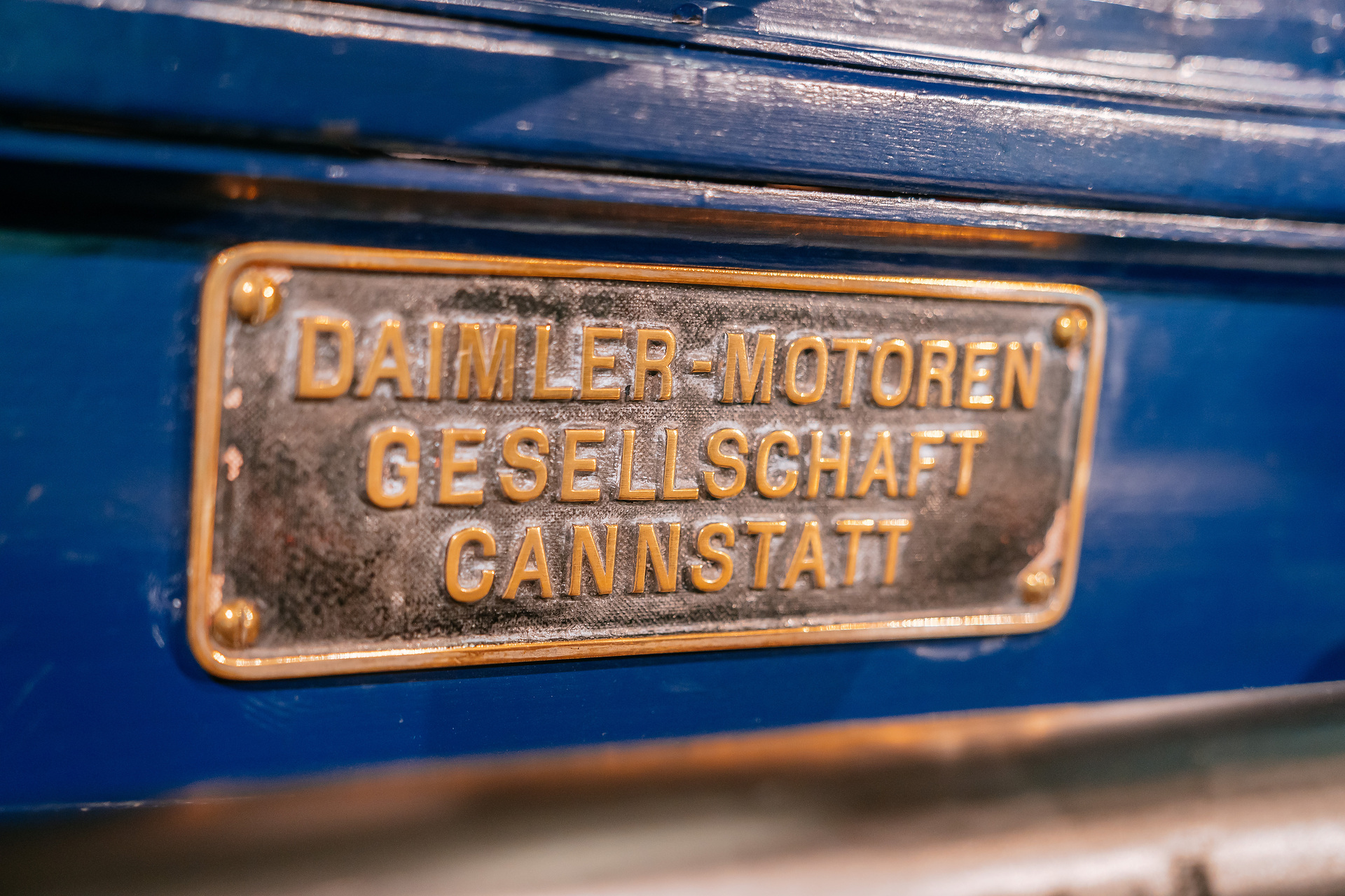Mercedes-Benz Museum, Raum Mythos 1: Pioniere – Die Erfindung des Automobils, 1886 bis 1900. Daimler Motor-Feuerspritze aus dem Jahr 1892 mit 3-Liter-Zweizylindermotor (5,1 kW/7 PS) als Pumpenantrieb und zur Bespannung mit Pferden. Detailaufnahme des Daimler-Fabrikschilds. Welcher Daimler-Motor ist so stark wie 32 Feuerwehrleute?