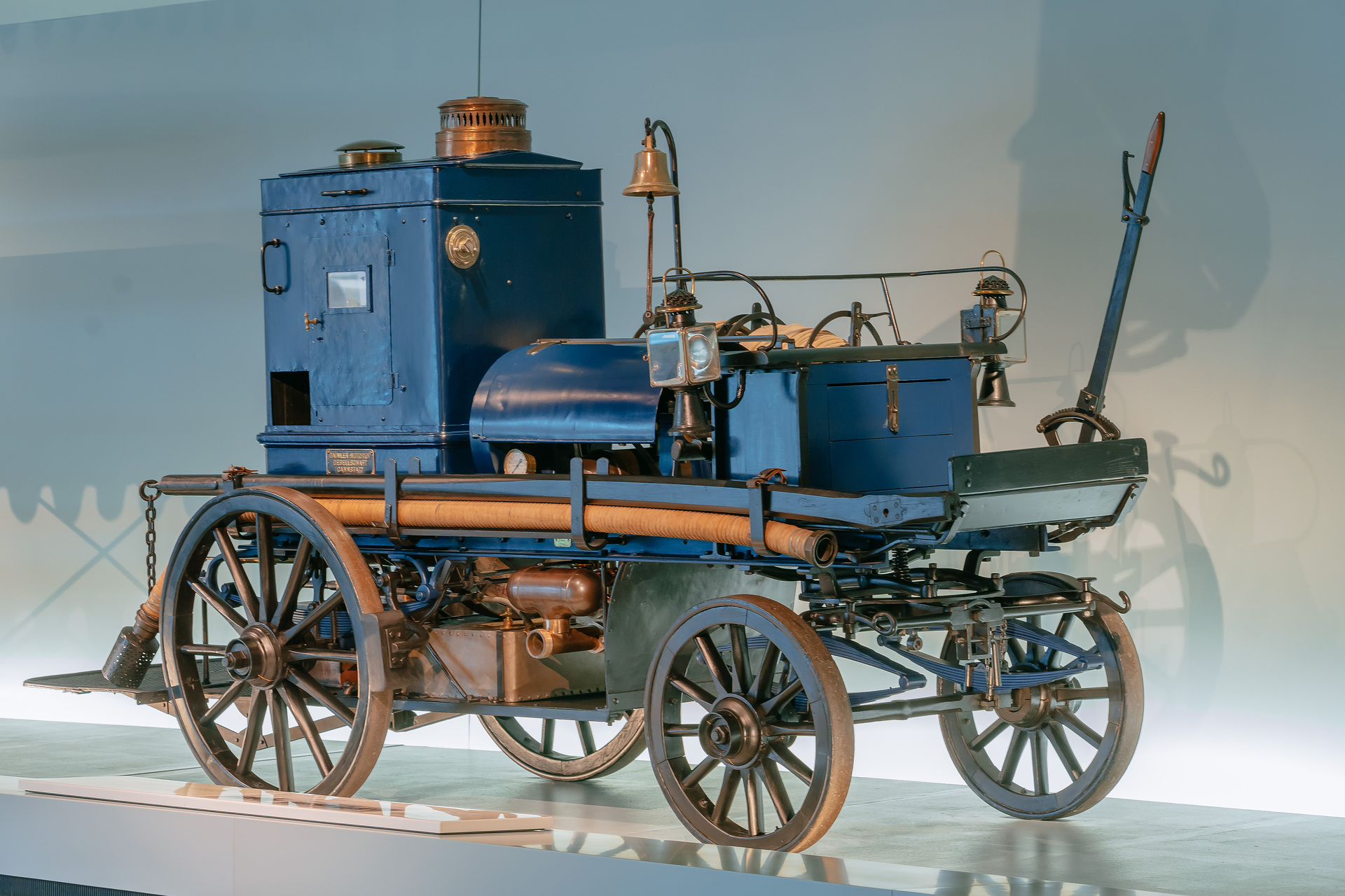 Mercedes-Benz Museum, Raum Mythos 1: Pioniere – Die Erfindung des Automobils, 1886 bis 1900. Daimler Motor-Feuerspritze aus dem Jahr 1892 mit 3-Liter-Zweizylindermotor (5,1 kW/7 PS) als Pumpenantrieb und zur Bespannung mit Pferden. Gesamtansicht von rechts vorn. Welcher Daimler-Motor ist so stark wie 32 Feuerwehrleute?