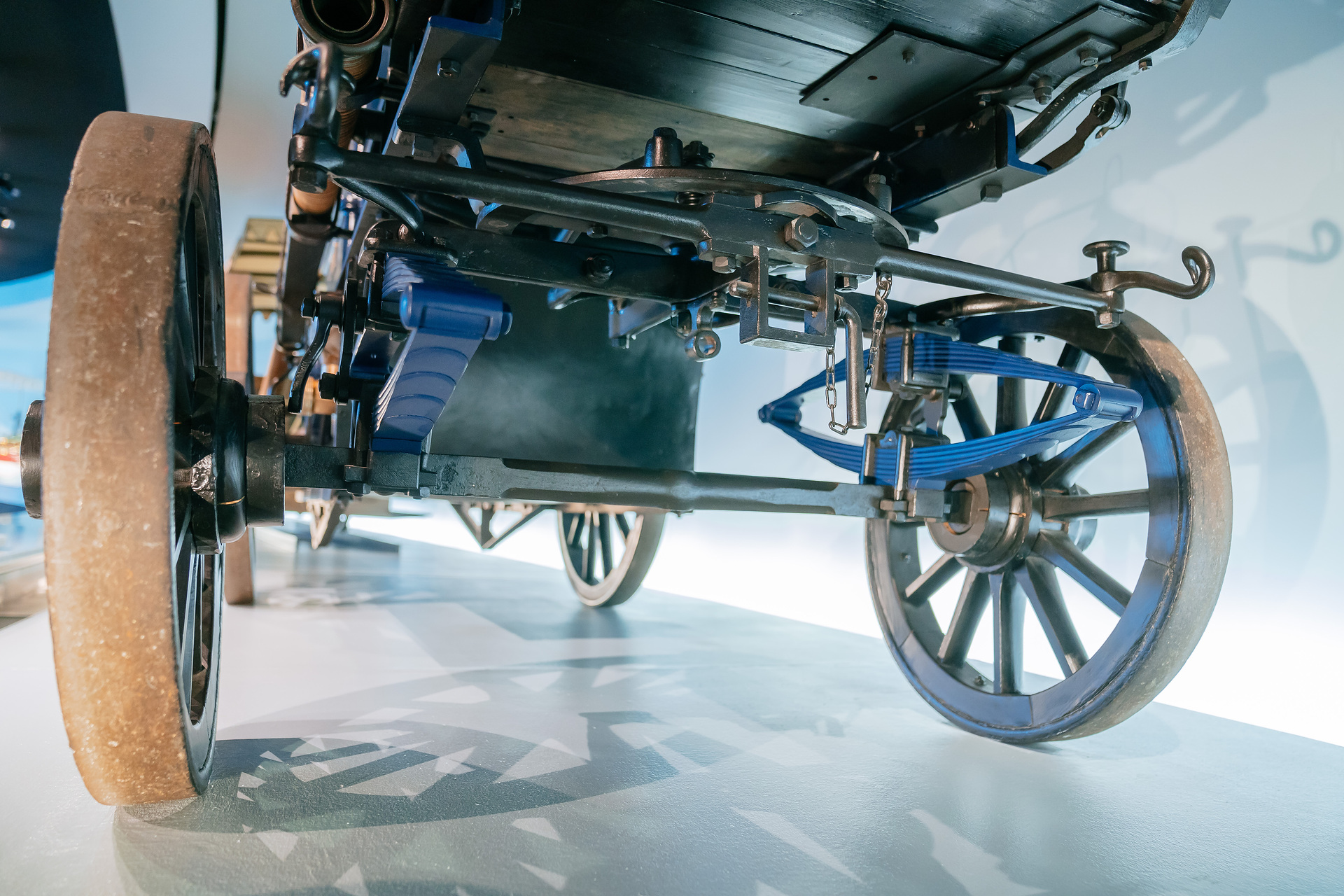 Mercedes-Benz Museum, Raum Mythos 1: Pioniere – Die Erfindung des Automobils, 1886 bis 1900. Daimler Motor-Feuerspritze aus dem Jahr 1892 mit 3-Liter-Zweizylindermotor (5,1 kW/7 PS) als Pumpenantrieb und zur Bespannung mit Pferden. Detailaufnahme der gefederten Vorderachse mit Drehschemel und der mit einem Bolzen gesicherten Deichselaufnahme. Welcher Daimler-Motor ist so stark wie 32 Feuerwehrleute?