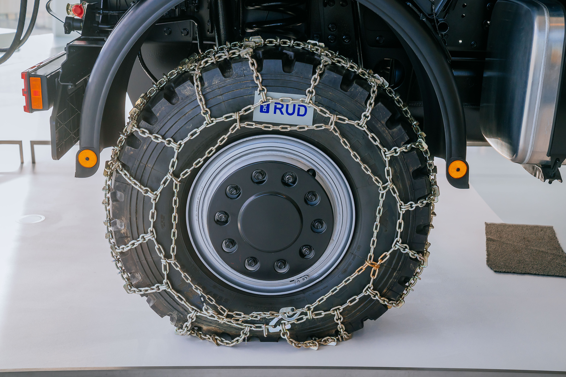 Mercedes-Benz Museum, Collection Room 3: The Gallery of Helpers. Mercedes-Benz Unimog U 500 of the 405 model series, winter service vehicle with snow blower, snow chains and gritting body from 2004. Close-up of the right rear wheel with snow chain. The universal solution against snow and icy roads: The Unimog U 500 with winter maintenance equipment