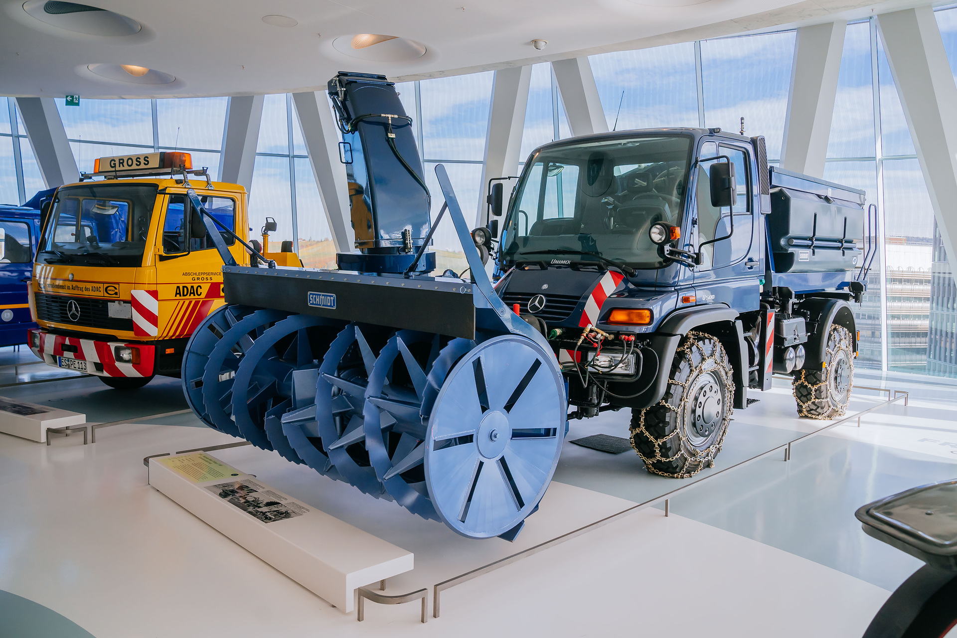 Mercedes-Benz Museum, Collection Room 3: The Gallery of Helpers. Mercedes-Benz Unimog U 500 of the 405 model series, winter service vehicle with snow blower, snow chains and gritting body from 2004. General view from the front left. The universal solution against snow and icy roads: The Unimog U 500 with winter maintenance equipment