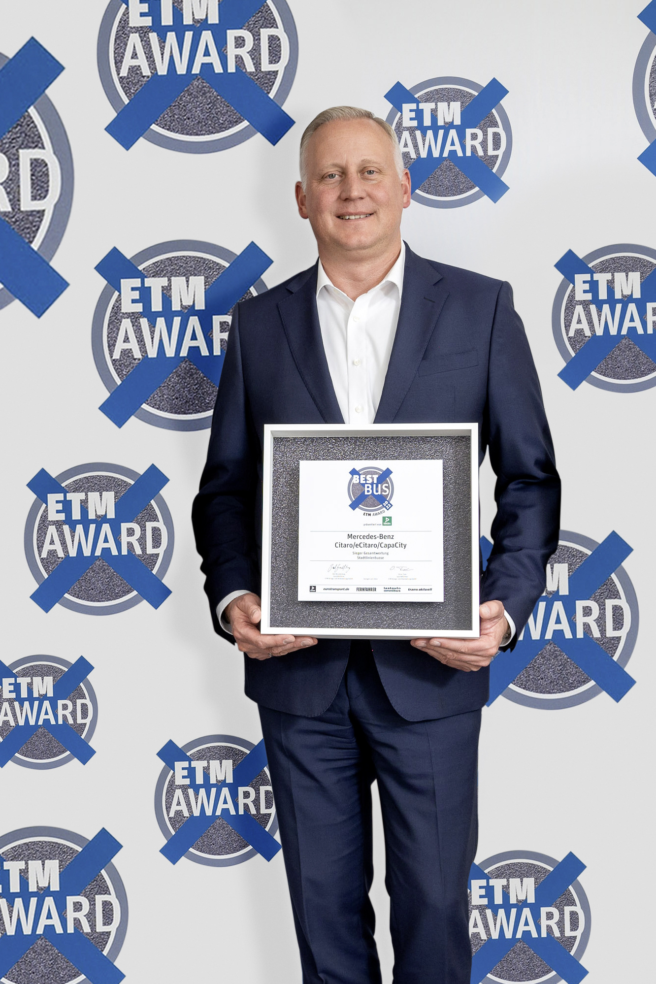 Mirko Sgodda, Leiter Marketing, Vertrieb und Customer Services mit dem ETM-Award in der Kategorie Stadtlinienbusse für die Mercedes-Benz Citaro Baureihe. So sehen Sieger aus: Nutzfahrzeuge der Daimler Truck AG gewinnen ETM Awards 2022 in acht Kategorien