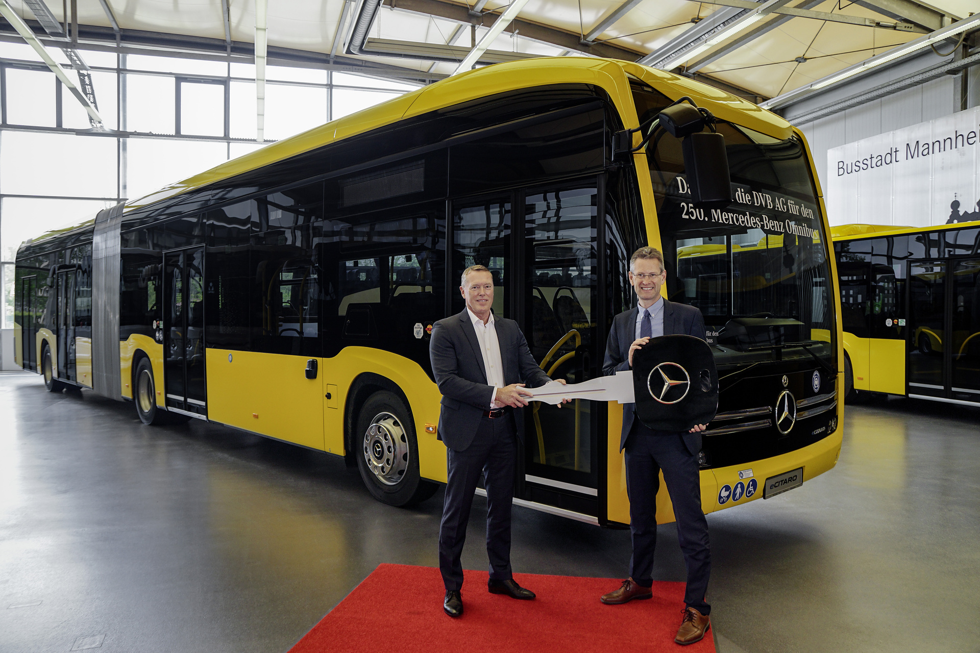 250th bus handover to Dresdner Verkehrsbetriebe AG (DVB). From right: Andreas Hemmersbach (Chief Financial Officer and Technical Officer of DVB, Rüdiger Kappel (Fleet Sales Manager at Daimler Buses Germany), vehicle: Mercedes-Benz eCitaro G with all-electric drive, Dresdner Verkehrsbetriebe AG, exterior, yellow, 4 x electric hub motor (2 x center axle, 2 x rear axle), 4 x 126 kW, 4 x 485 Nm, 5 HV battery packs, 64,5 kWh per HV battery pack, Preventive Brake Assist, Sideguard Assist, length/width/height: 18.125 /2550/3400 mm, passenger capacity: 1/157 Dresden steht unter Strom Verkehrsbetriebe der Landeshauptstadt stellen Buslinie 68 mit Mercedes-Benz eCitaro auf Elektrobetrieb um