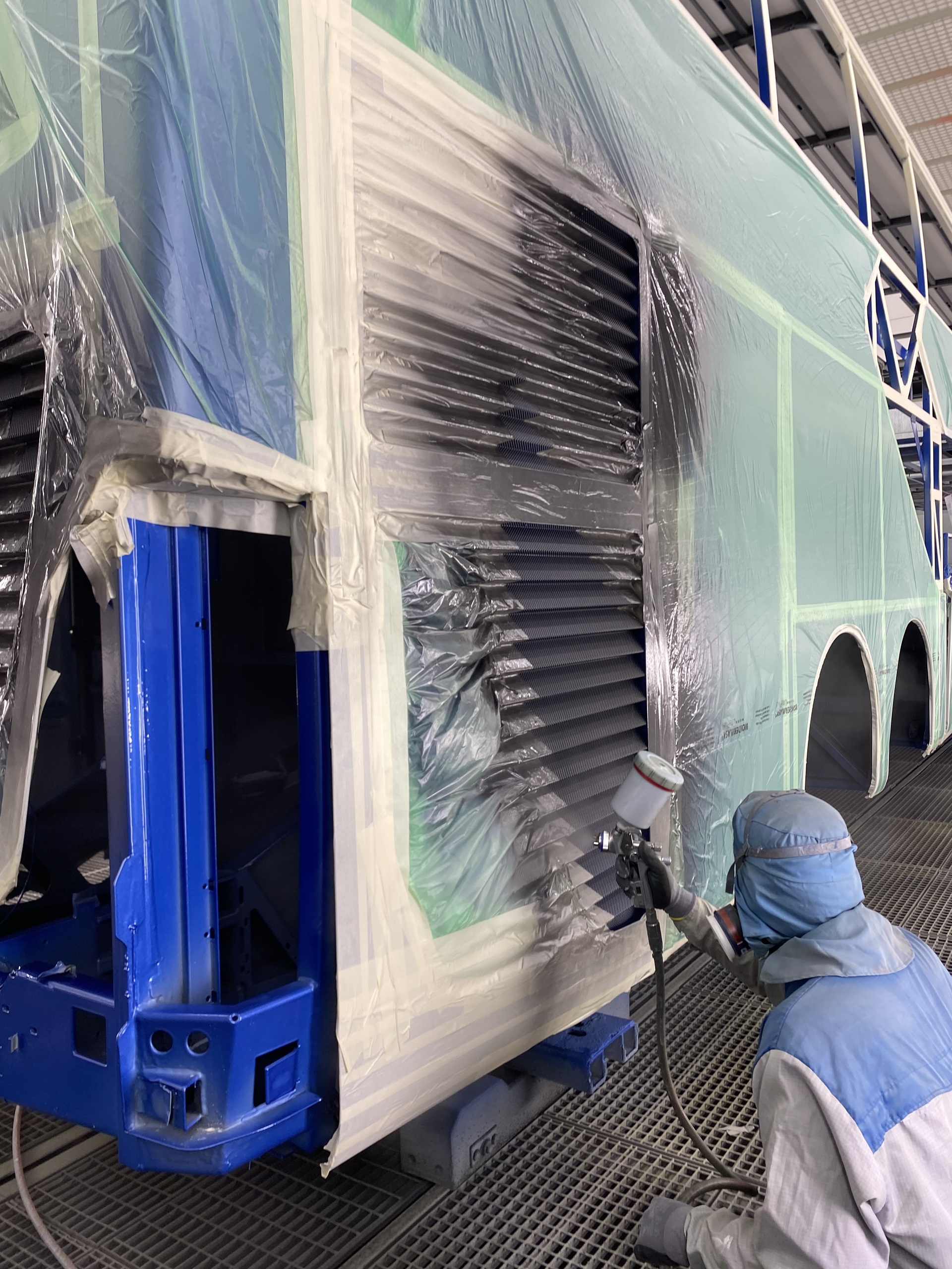 Ein Mitarbeiter der Lackierung am Standort Neu-Ulm bei der Applikation des individuellen Kundenmotivs Farbenfrohes Jubiläum: Daimler Buses Werk Neu-Ulm lackiert 100.000sten Bus