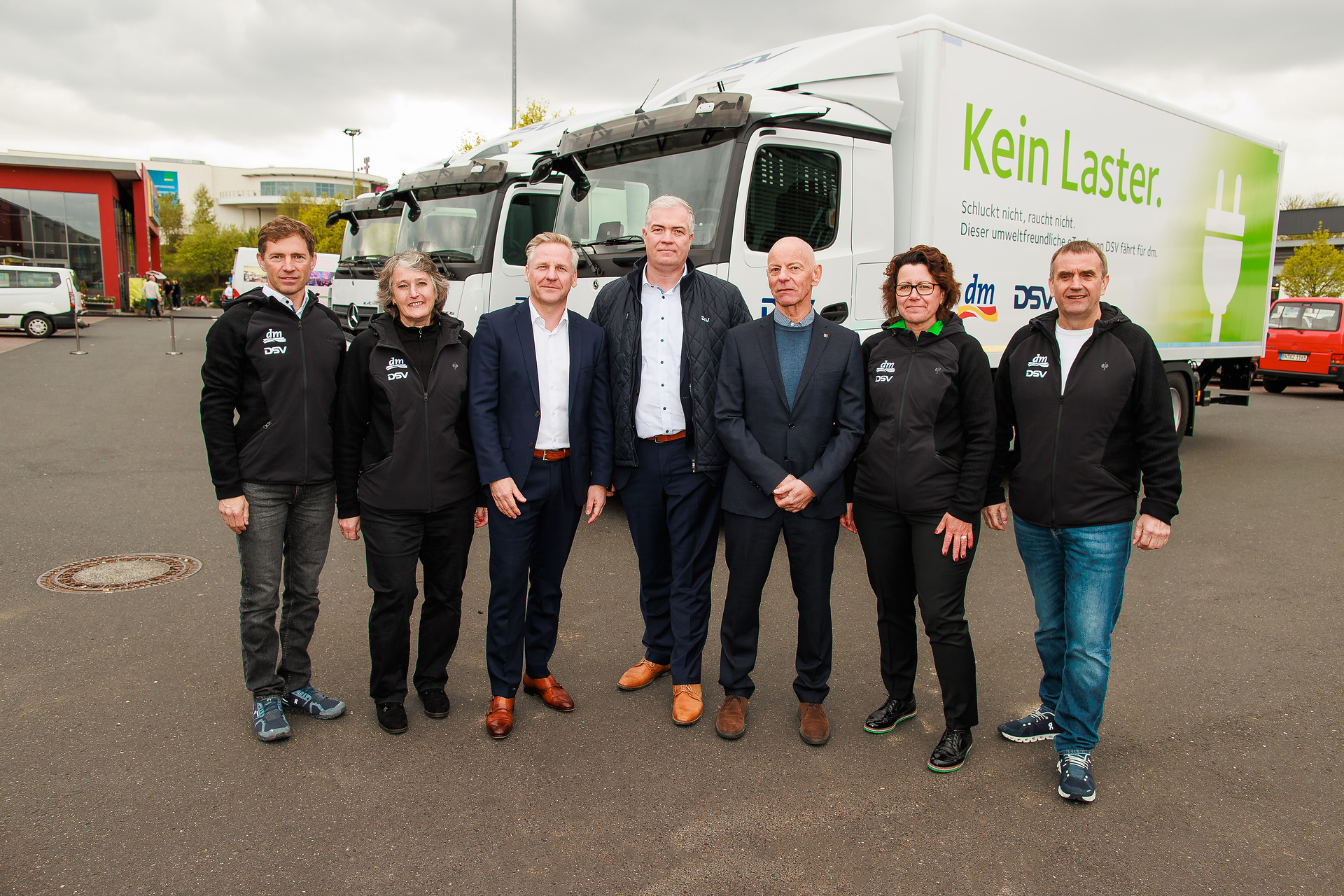 Von links: Michael Sternbeck (Bereichsverantwortlicher Logistikmanagement Filiale, dm-drogerie markt), Ursula Paepcke (Ressort Logistik, Bereichsverantwortliche TKM, dm-drogerie markt), Ronald Ott (Leitung Sales LKW Deutschland Mercedes-Benz & FUSO, Daimler Truck AG), Markus Walke (Director, Business Organisation & Compliance DACH, DSV), Rolf Wetzel (Senior Director, RDS/Road Plus, DSV), Nadine Siemes (Director Transport RDS, DSV), Christian Bodi (Geschäftsführer Ressort Logistik, dm-drogerie markt) All-electric deliveries to drugstores - Three Mercedes-Benz eActros trucks in use at DSV