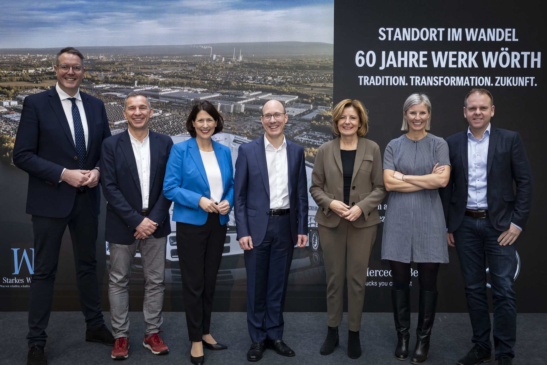 Zu den Teilnehmern zählten Alexander Schweitzer, Minister für Arbeit, Soziales, Transformation und Digitalisierung des Landes Rheinland Pfalz, Thomas Zwick, Betriebsratsvorsitzender des Mercedes-Benz Werks Wörth, Daniela Schmitt, Ministerin für Wirtschaft, Verkehr, Landwirtschaft und Weinbau des Landes Rheinland-Pfalz, Andreas Bachhofer, Standortverantwortlicher des Werks Wörth und Produktionsleiter von Mercedes-Benz Trucks, Malu Dreyer, Ministerpräsidentin des Landes Rheinland-Pfalz, Karin Rådström, CEO Mercedes-Benz Trucks, sowie Jürgen Distl, Head of Operations and CFO Mercedes-Benz Trucks. Höhepunkt des Jubiläumsjahres im Mercedes-Benz Werk Wörth: 60 Jahre Tradition – Transformation – Zukunft