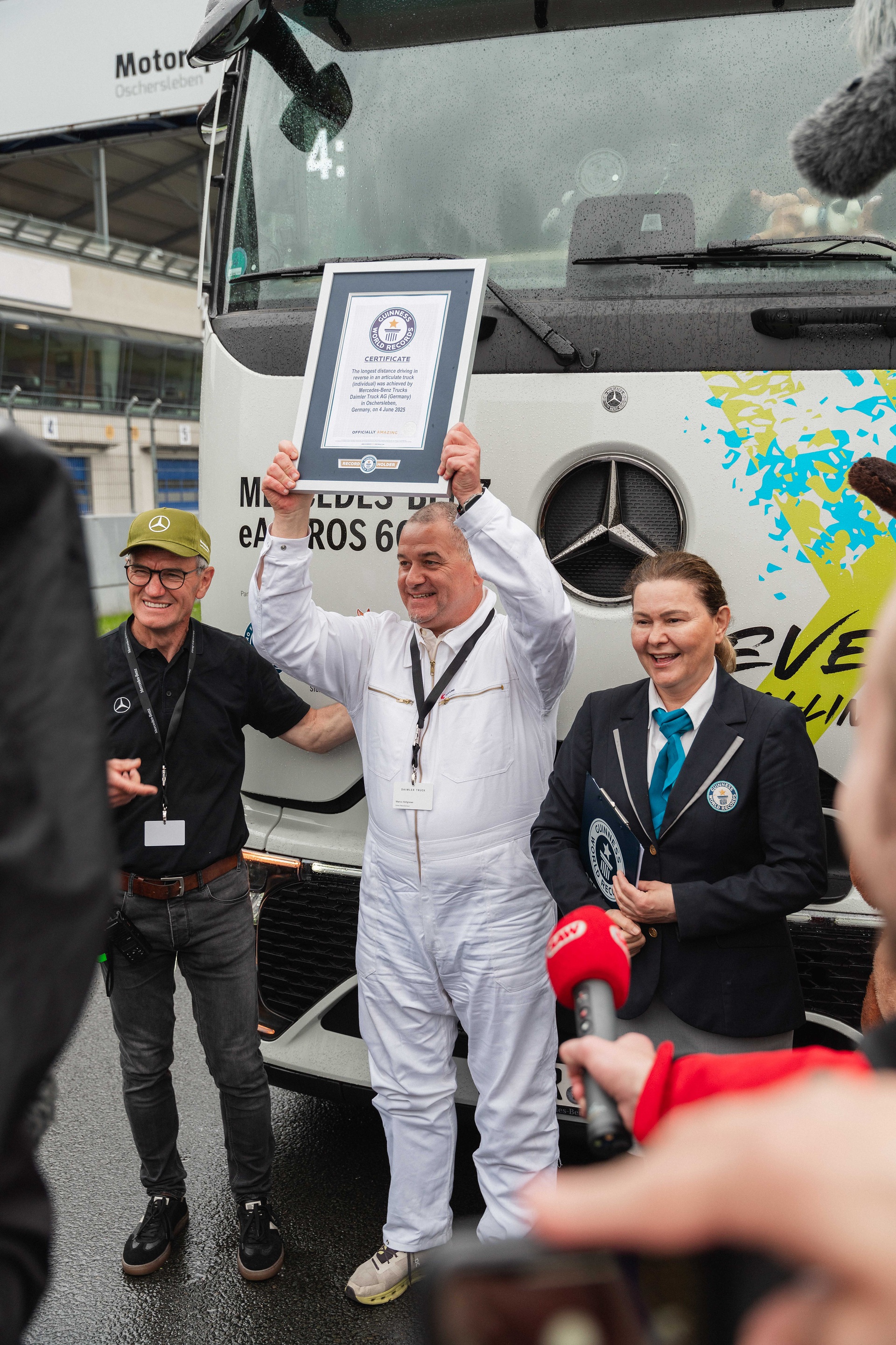 GUINNESS WORLD RECORDS™-Titel für die längste rückwärtsgefahrene Strecke mit einem Sattelzug (Einzelperson) geholt. Marco Hellgrewe (Mitte) und Werner Kempfle, Entwicklungsingenieur und Co-Projektleiter des eActros 600, nehmen die Auszeichnung von Seyda Subasi-Gemici, Jurorin, Guinness World Records Limited, entgegen. Mercedes-Benz Trucks bricht GUINNESS WORLD RECORDS™-Weltrekord mit eActros 600