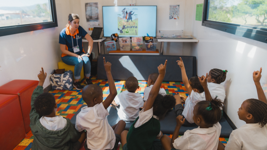 Schüler:innen gemeinsam mit ihrer Lehrerin in der Schule