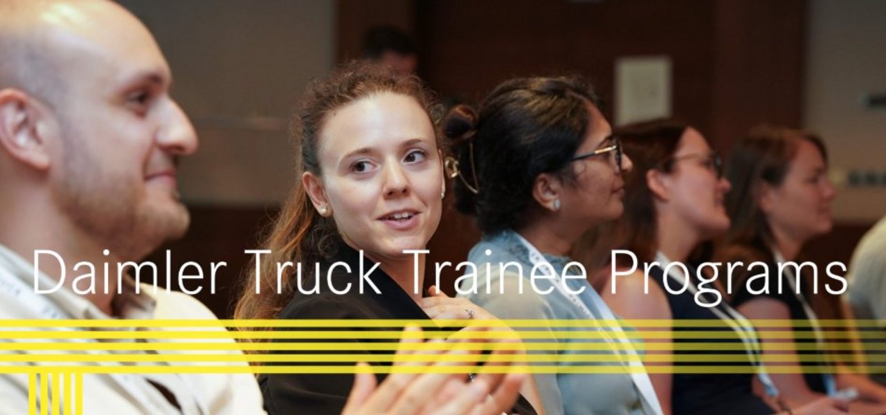 Eine Gruppe von Trainees in einem Seminarraum, die aufmerksam einem Vortrag zuhören, mit dem Schriftzug „Daimler Truck Trainee Programs“ im Vordergrund.